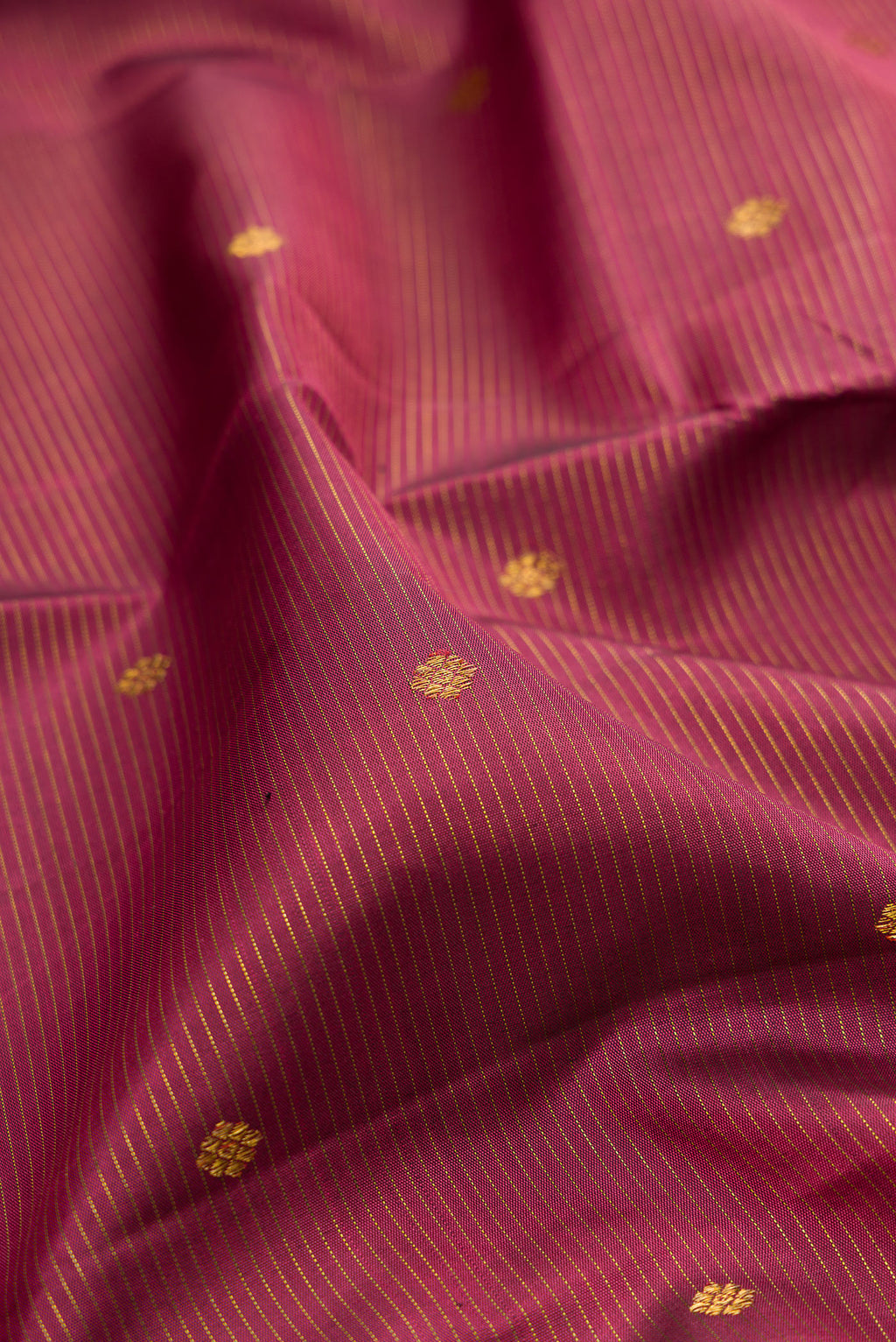 Close up of Rose Gold Dual Tone Kanjivaram Silk Saree with Stripes on the body and Fancy Border.  displaying folds