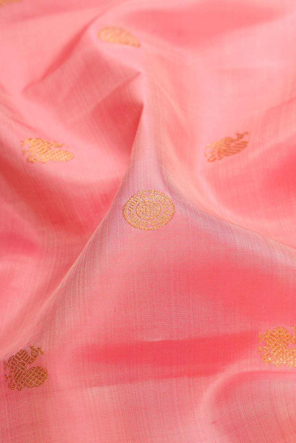 Close up of Peach Dual Tone Kanjivaram Silk Saree with Zari Butta on the body and Fancy Border.  displaying folds