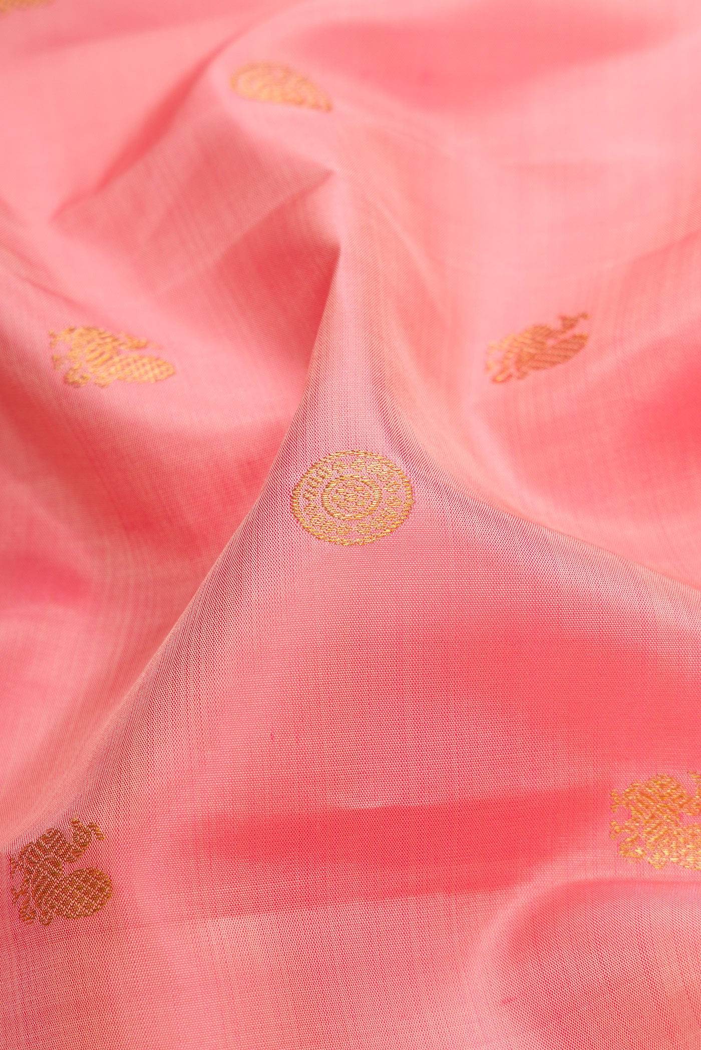 Close up of Peach Dual Tone Kanjivaram Silk Saree with Zari Butta on the body and Fancy Border.  displaying folds