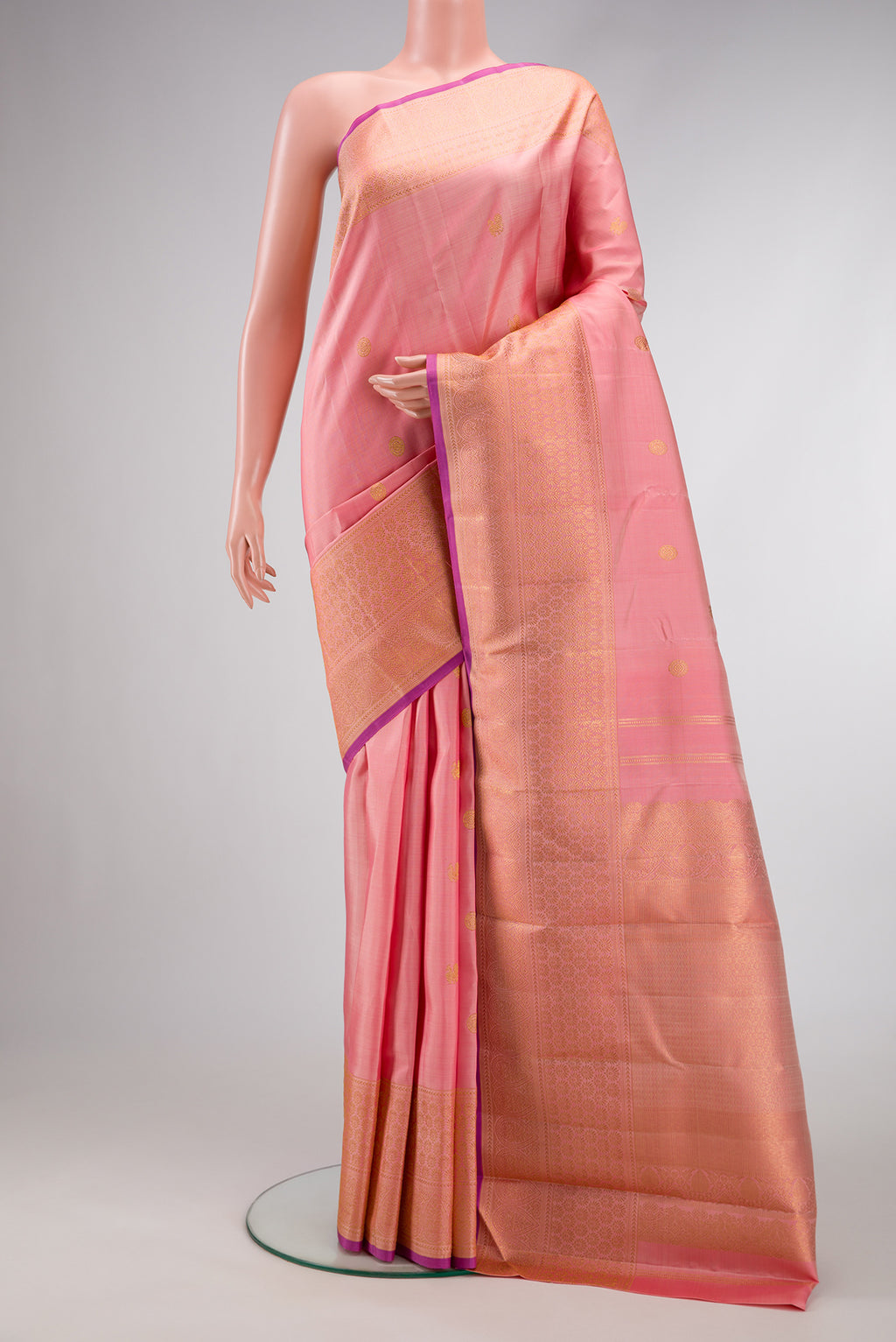 Peach Dual Tone Kanjivaram Silk Saree with Zari Butta on the body and Fancy Border.  displayed on a mannequin