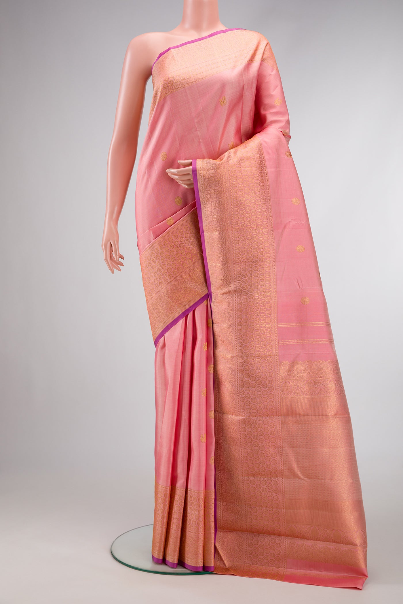 Peach Dual Tone Kanjivaram Silk Saree with Zari Butta on the body and Fancy Border.  displayed on a mannequin