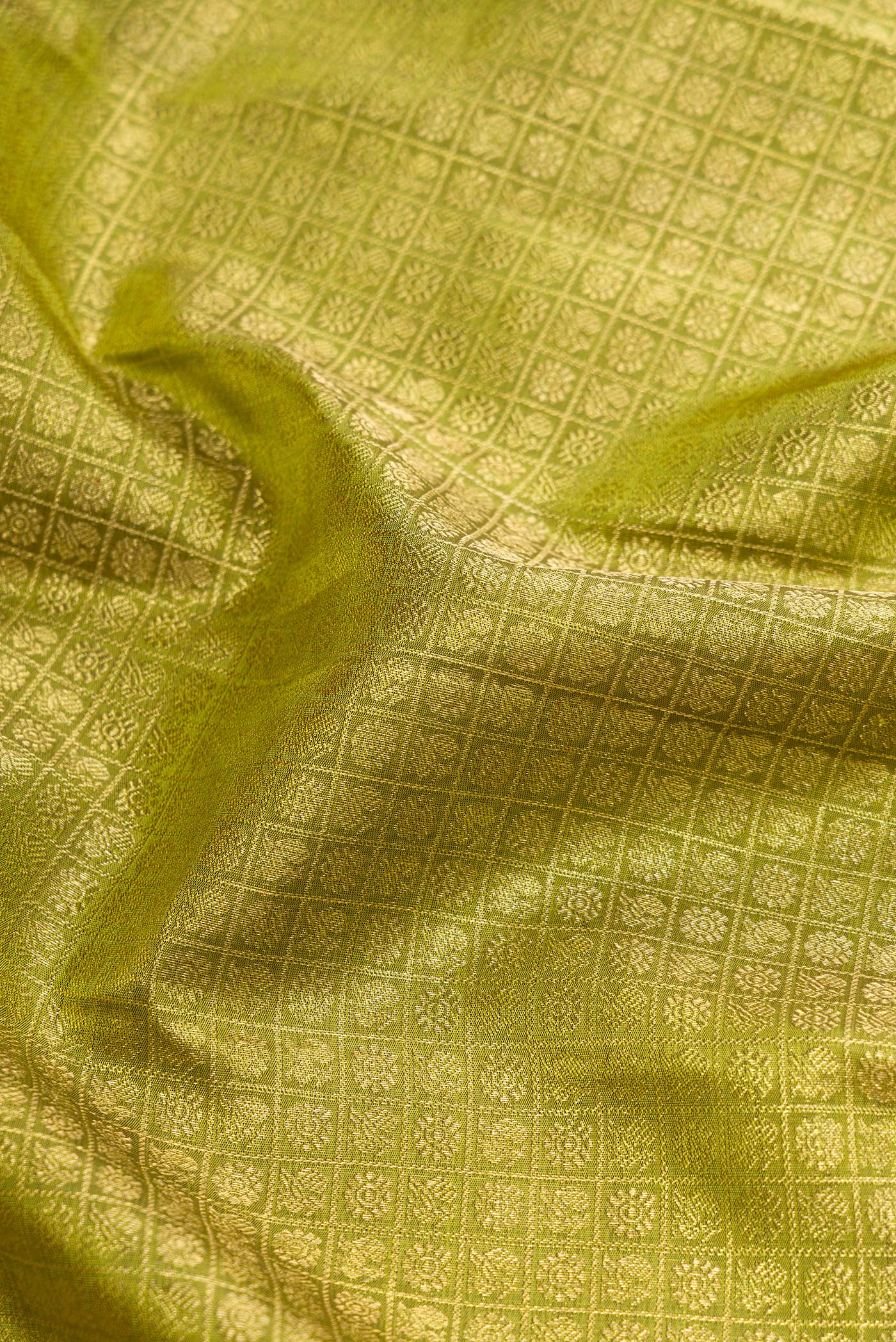 Close up of Pure Silk Pure Zari Green Dual Tone Kanjivaram Saree with Zari Brocade on the body and Zari Border.  displaying folds