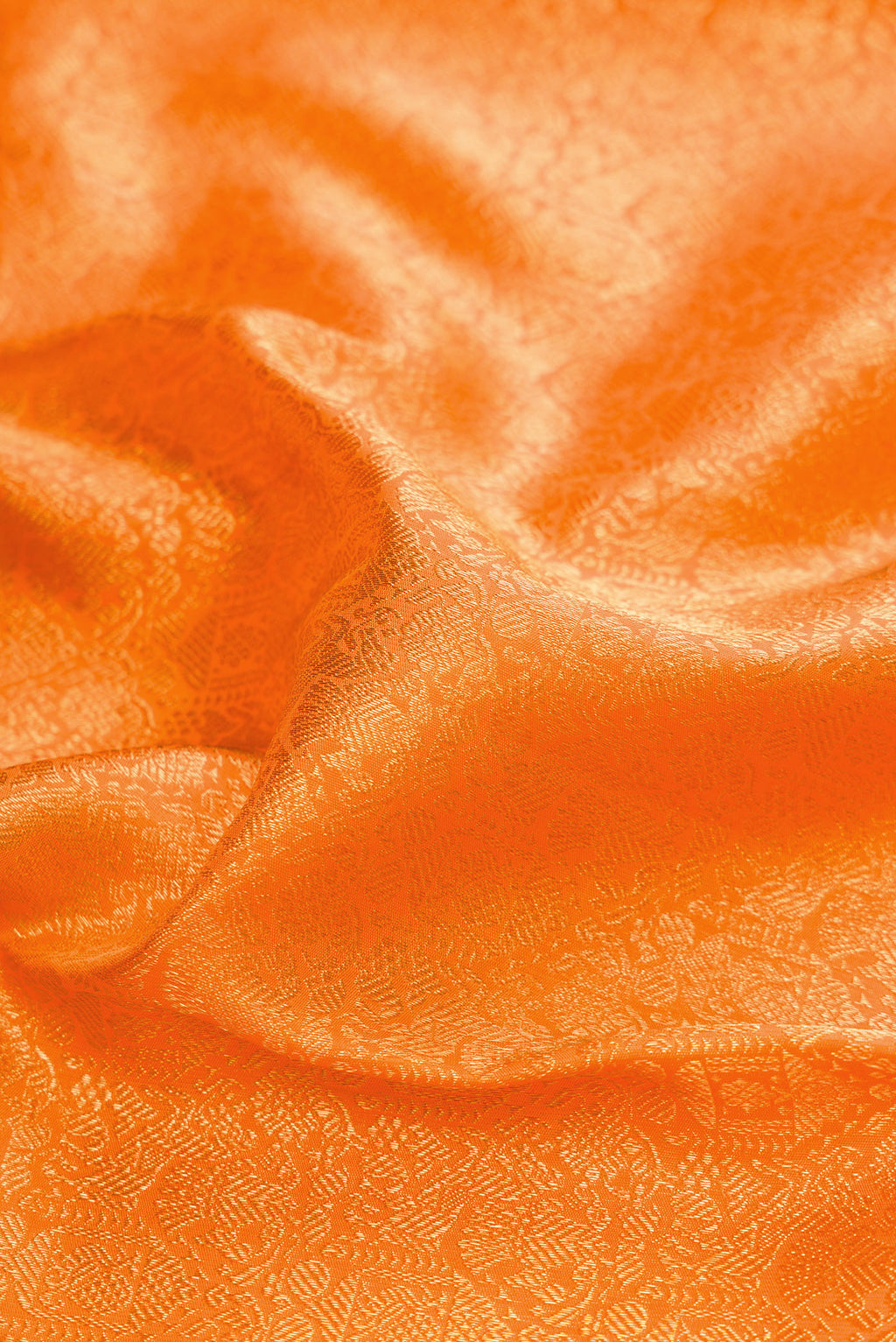 Close up of Orange Dual Tone Kanjivaram Silk Saree with Zari Brocade on the body and Zari Border.  displaying folds