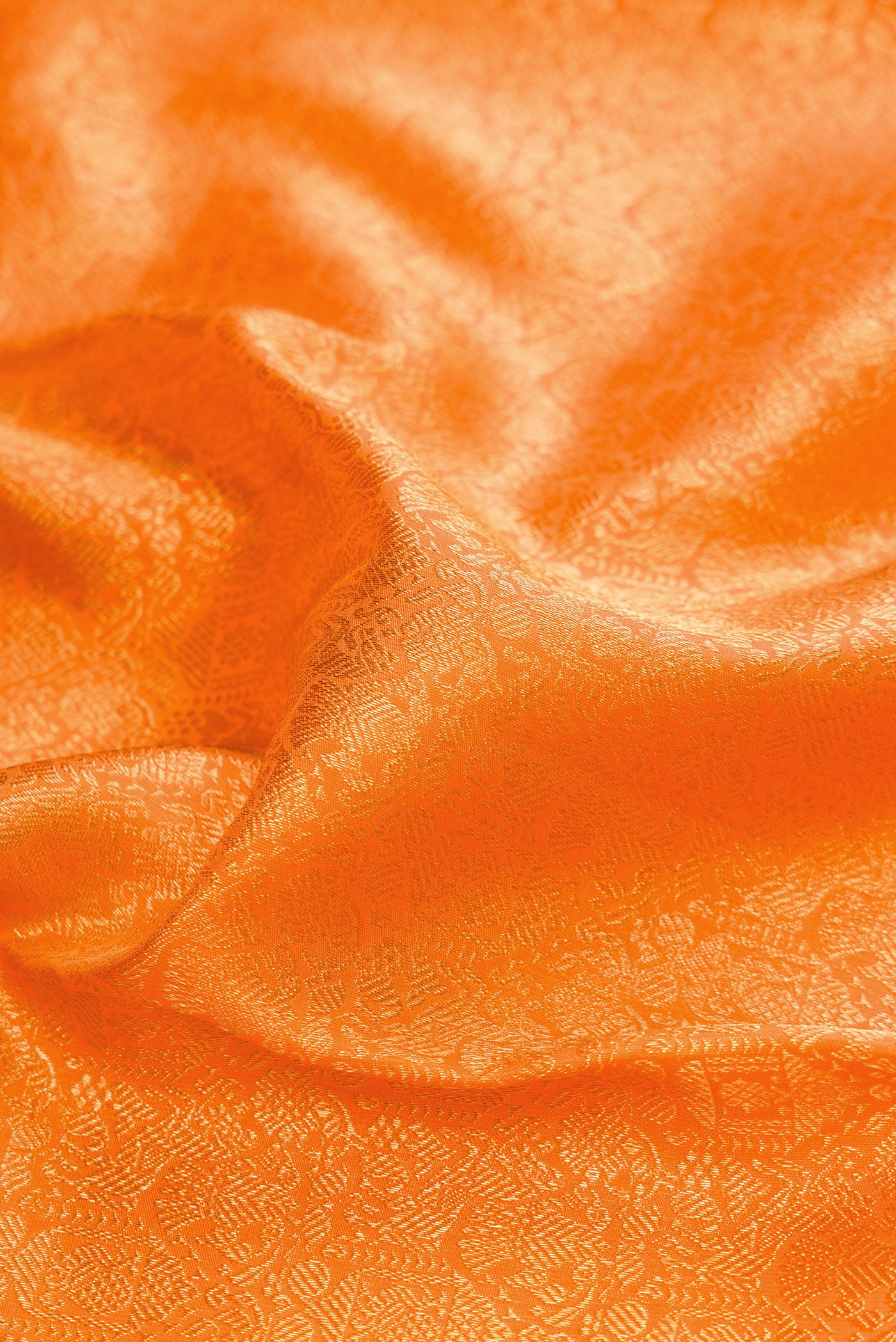 Close up of Orange Dual Tone Kanjivaram Silk Saree with Zari Brocade on the body and Zari Border.  displaying folds
