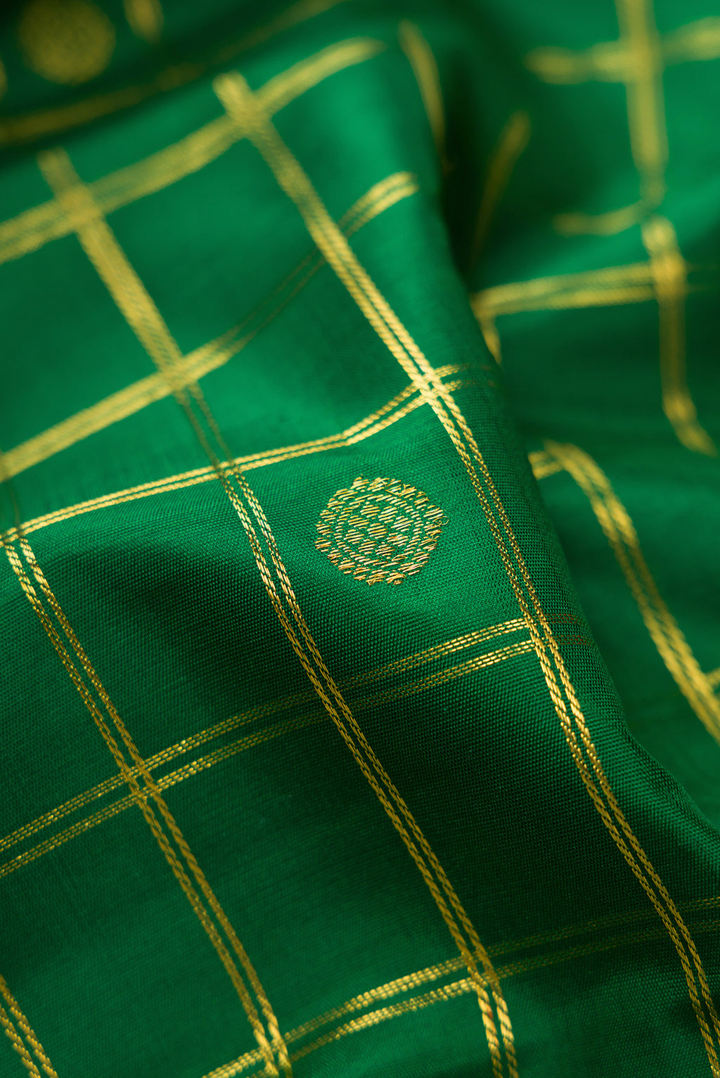 Close up of Pure Silk Pure Zari Green Kanjivaram Saree with Checked design on the body and Zari Border.  displaying folds
