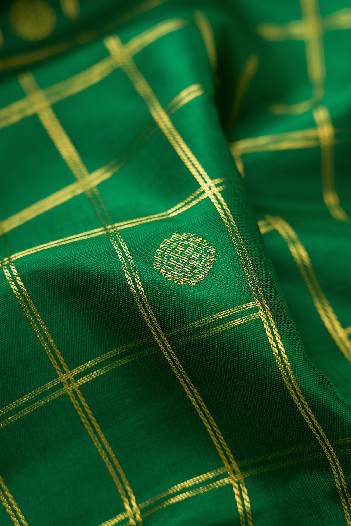 Close up of Pure Silk Pure Zari Green Kanjivaram Saree with Checked design on the body and Zari Border.  displaying folds