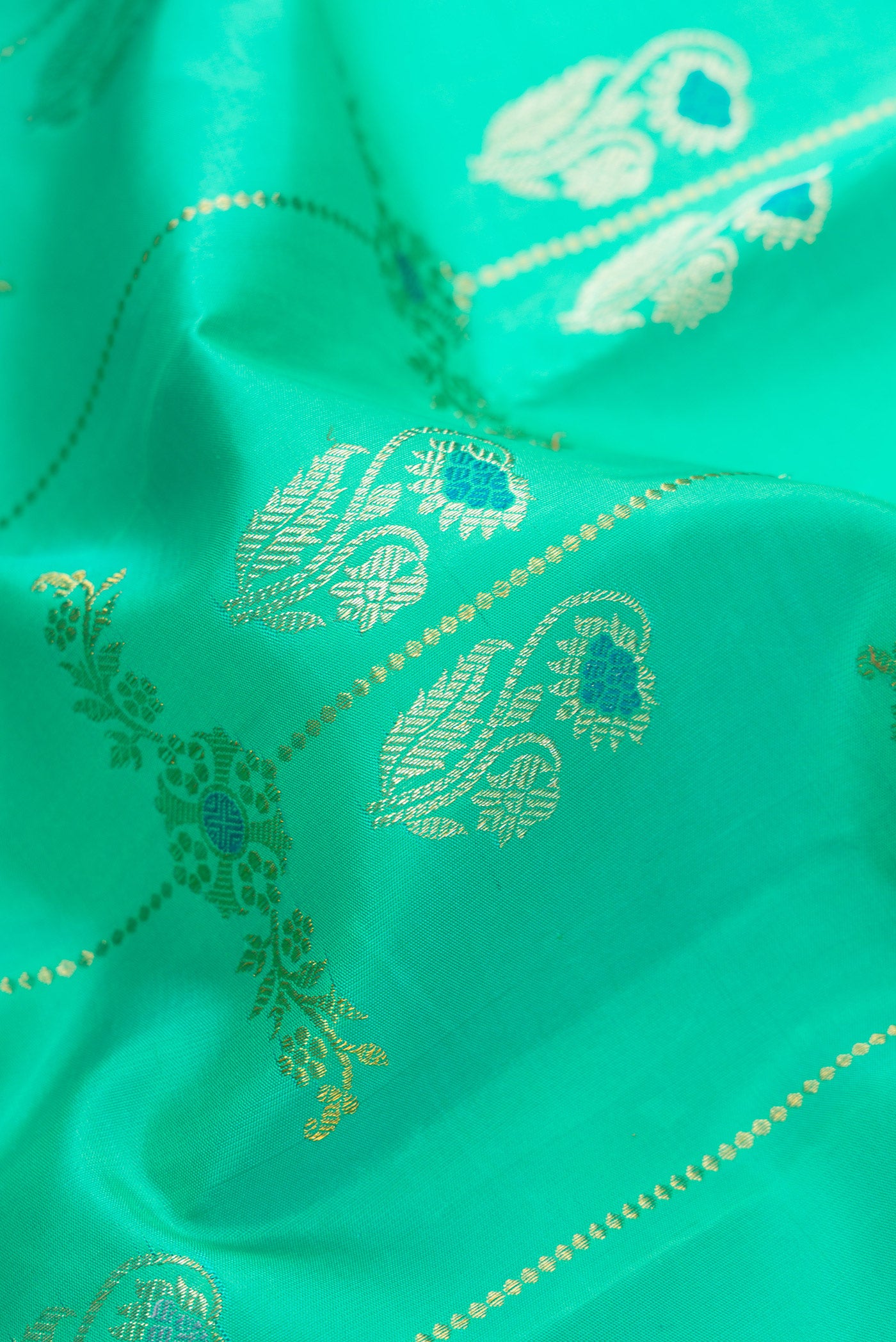 Close up of Pure Silk Pure Zari Sea Green Dual Tone Kanjivaram Saree with Zari Butta on the body and Zari Border.  displaying folds