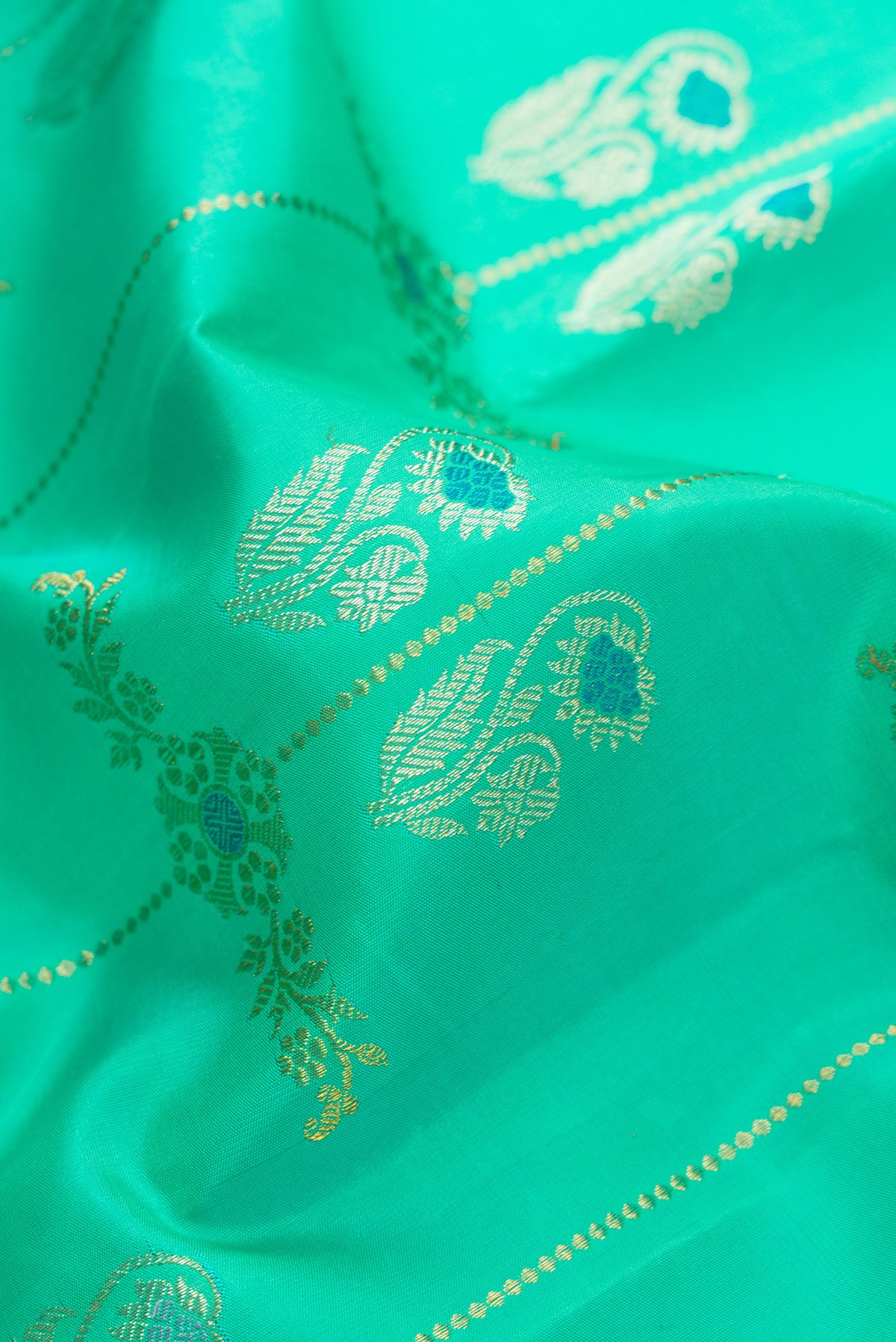 Close up of Pure Silk Pure Zari Sea Green Dual Tone Kanjivaram Saree with Zari Butta on the body and Zari Border.  displaying folds