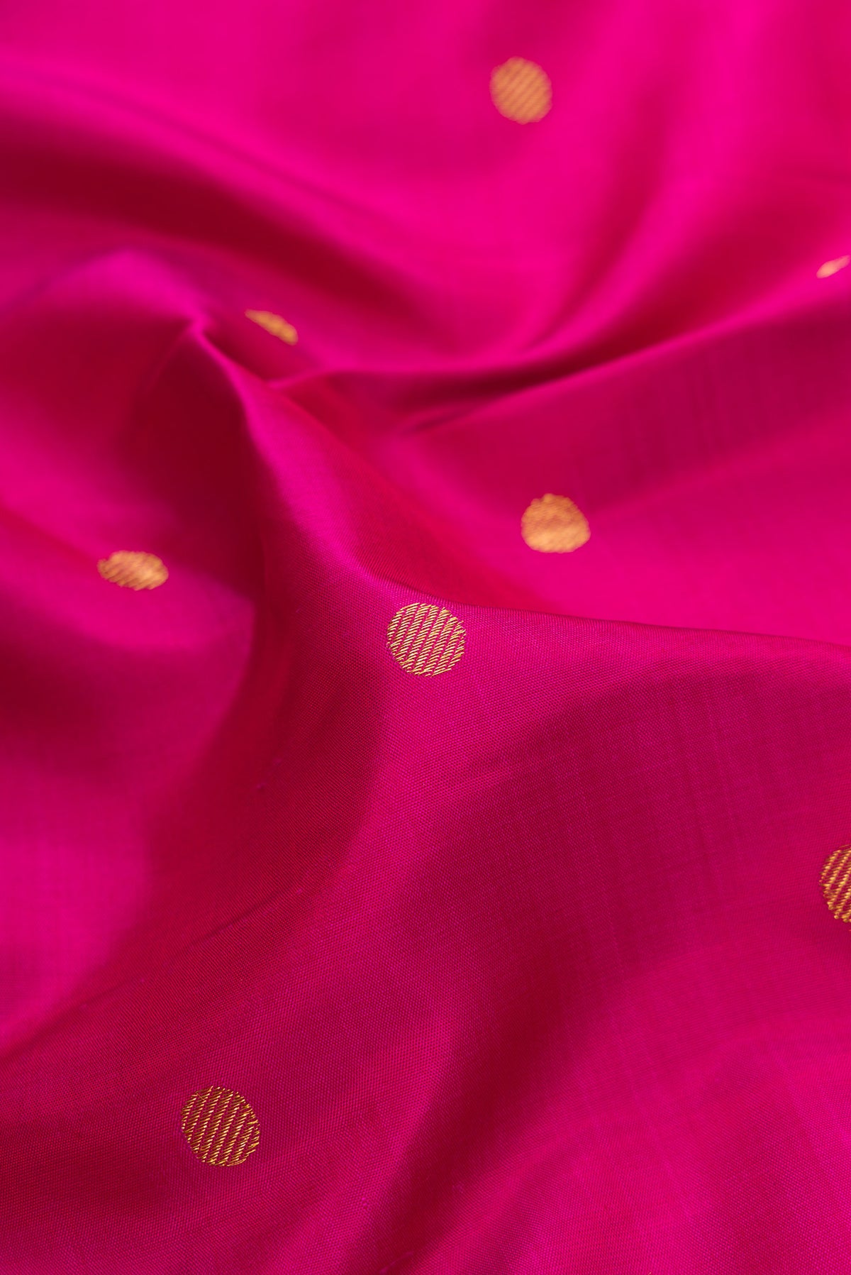 Close up of Pure Silk Pure Zari Magenta Dual Tone Kanchipuram Saree with Zari Butta on the body and Fancy Border.  displaying folds