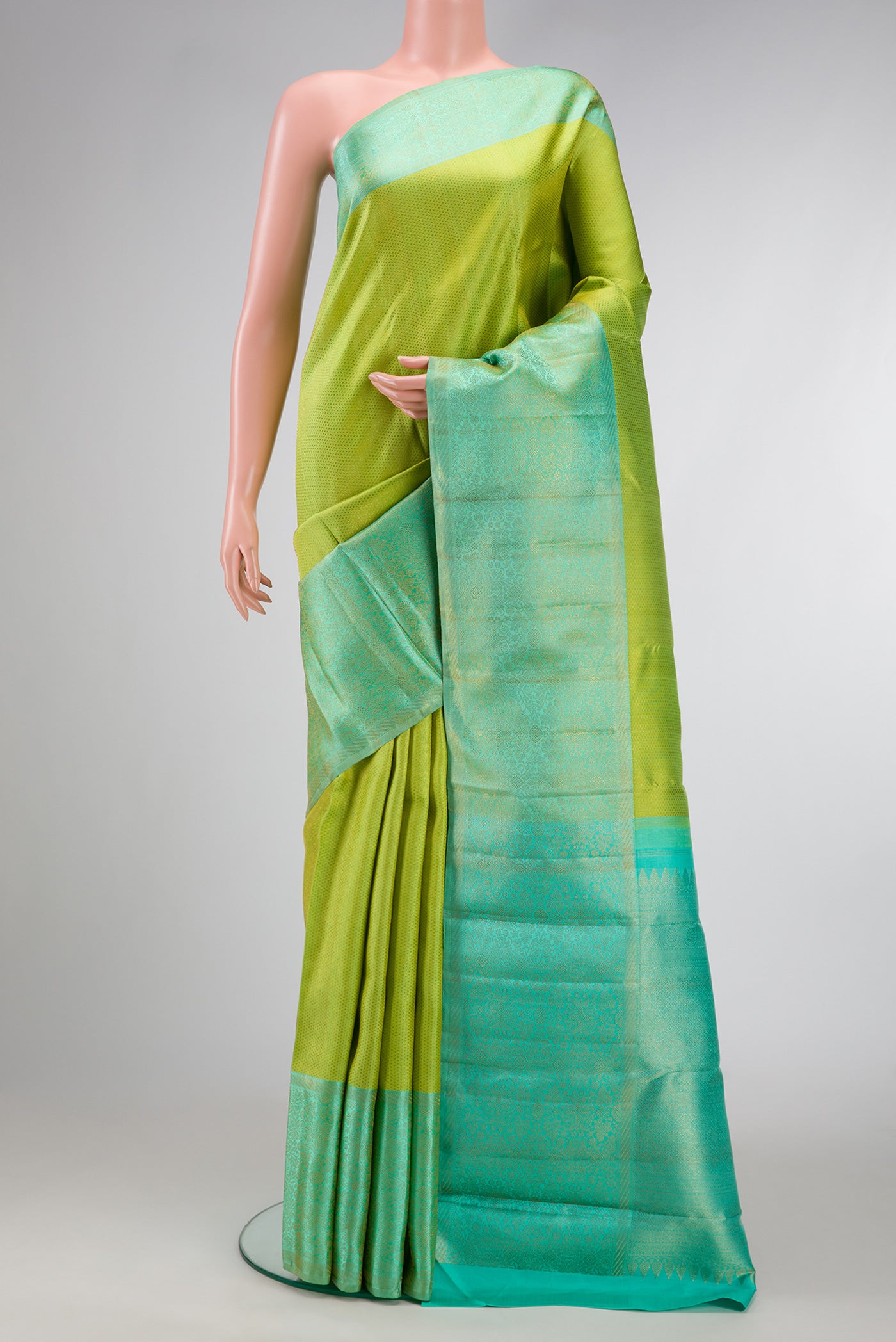 Parrot Green Dual Tone Kanchipuram Silk Saree with Zari Brocade on the body and Zari Border.  displayed on a mannequin