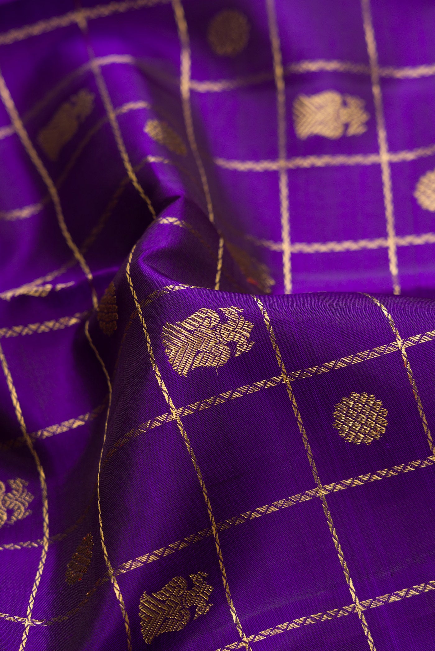 Close up of Pure Silk Pure Zari Violet Dual Tone Kanjivaram Saree with Checked design on the body and Zari Border.  displaying folds