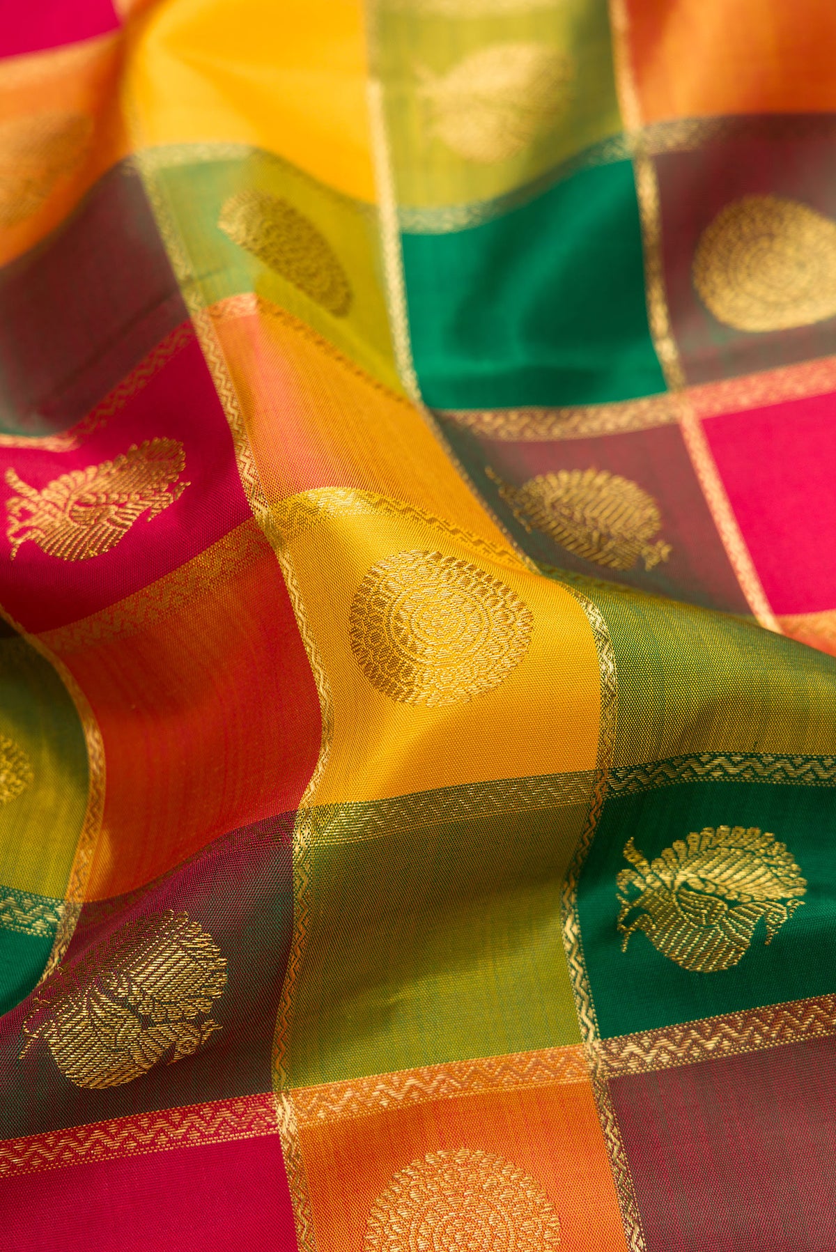 Close up of Pure Silk Pure Zari Yellow, Maroon and Green Color Kanjivaram Saree with Checked design on the body and Zari Border.  displaying folds