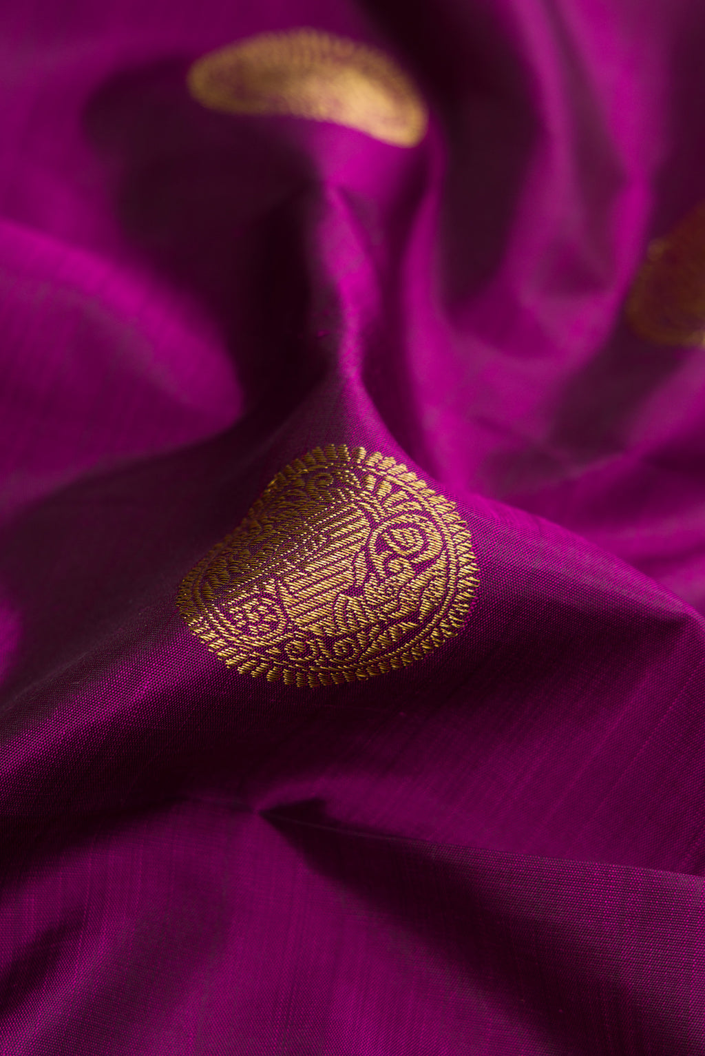 Close up of Pure Silk Pure Zari Purple Dual Tone Kanjivaram Saree with Zari Butta on the body and Zari Border.  displaying folds