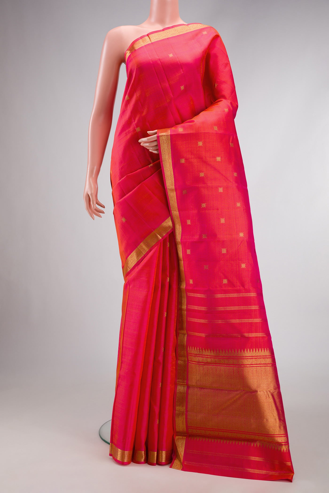 Pure Silk Pure Zari Coral Dual Tone Kanchipuram Saree with Zari Butta on the body and Zari Border.  displayed on a mannequin