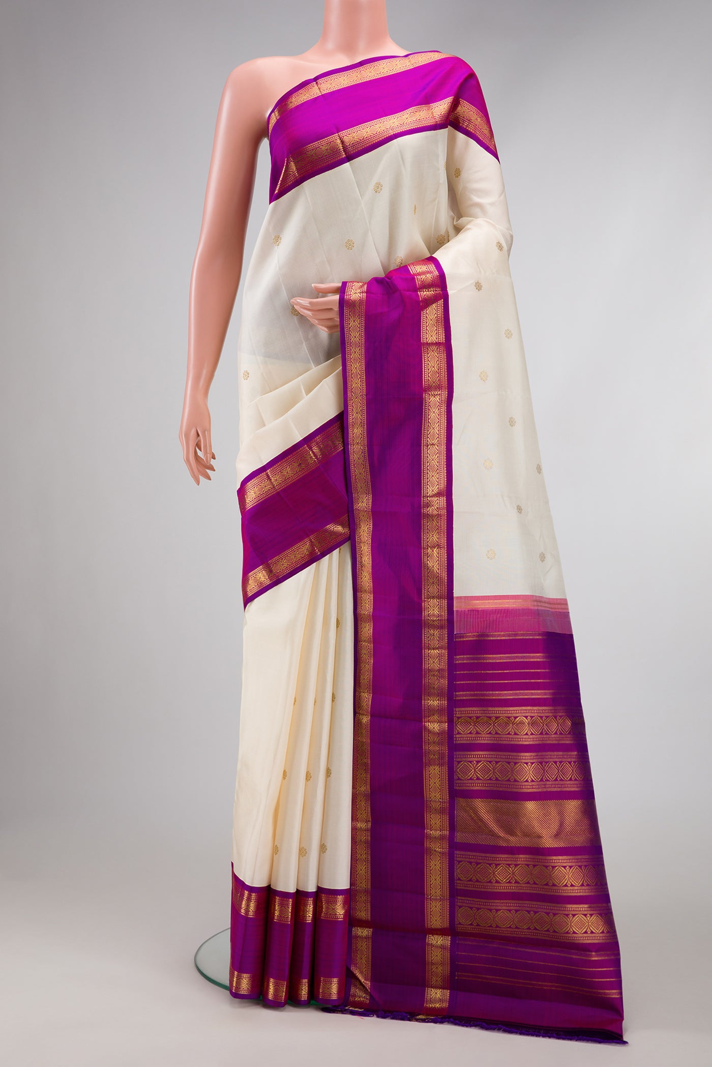 Pure Silk Pure Zari Off White Dual Tone Kanjivaram Saree with Zari Butta on the body and Zari Border.  displayed on a mannequin