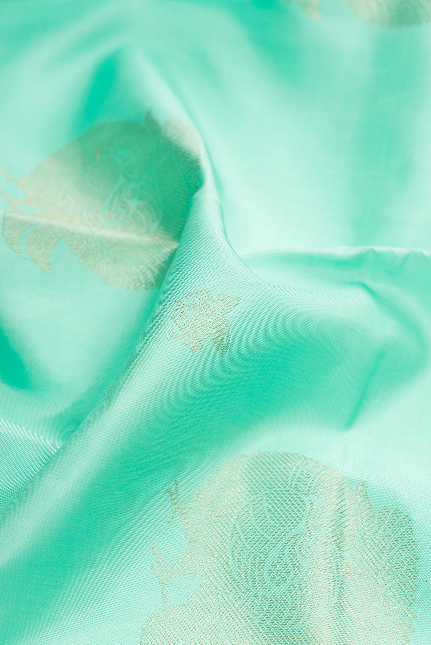 Close up of Pure Silk Pure Zari Sea Green Dual Tone Kanjivaram Saree with Zari Butta on the body and Paithani Border.  displaying folds