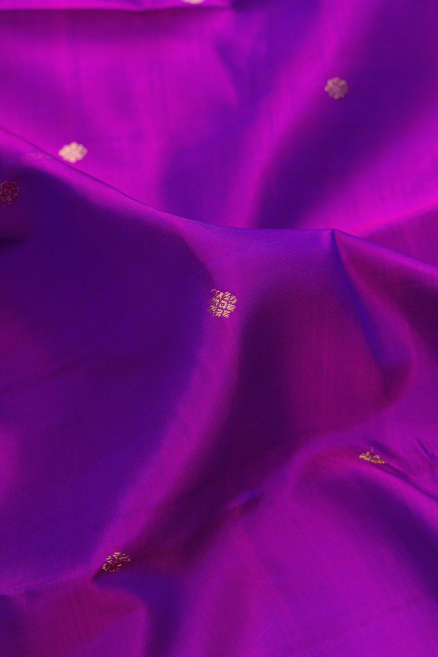 Close up of Pure Silk Pure Zari Purple Dual Tone Kanjivaram Saree with Zari Butta on the body and Fancy Border.  displaying folds