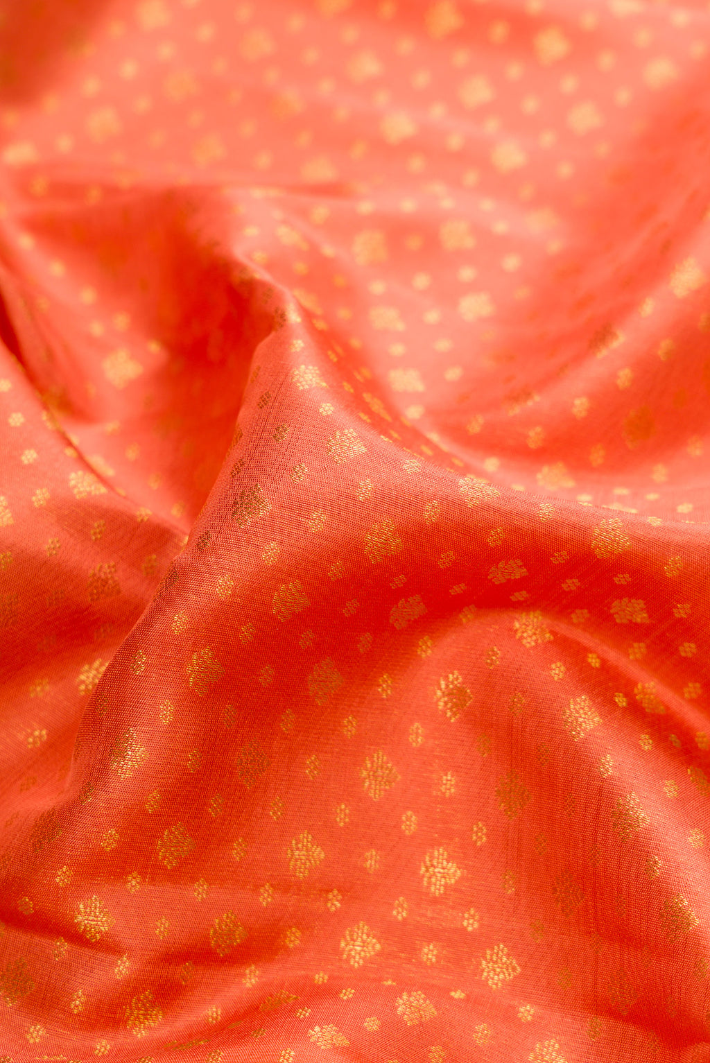 Close up of Pure Silk Pure Zari Peach Dual Tone Kanjivaram Saree with Zari Brocade on the body and Zari Border.  displaying folds