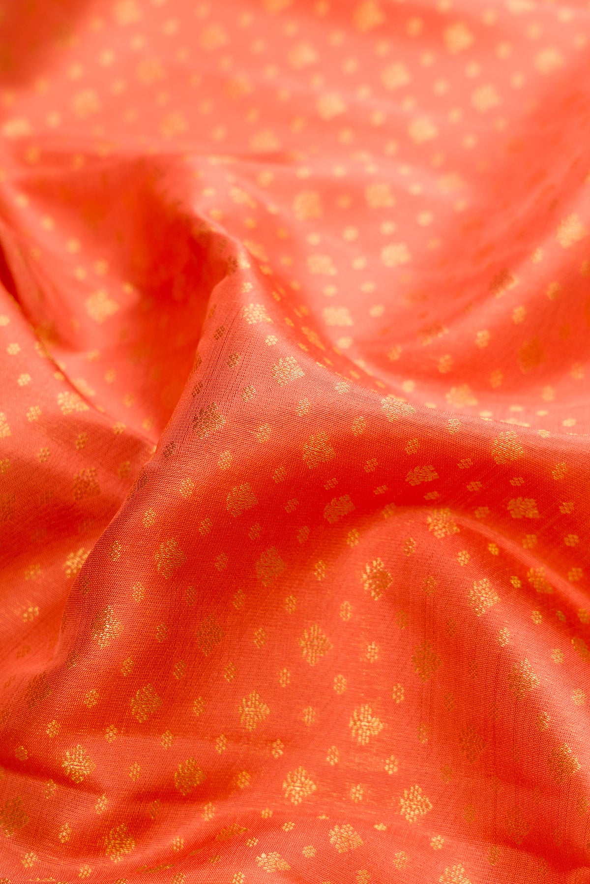 Close up of Pure Silk Pure Zari Peach Dual Tone Kanjivaram Saree with Zari Brocade on the body and Zari Border.  displaying folds