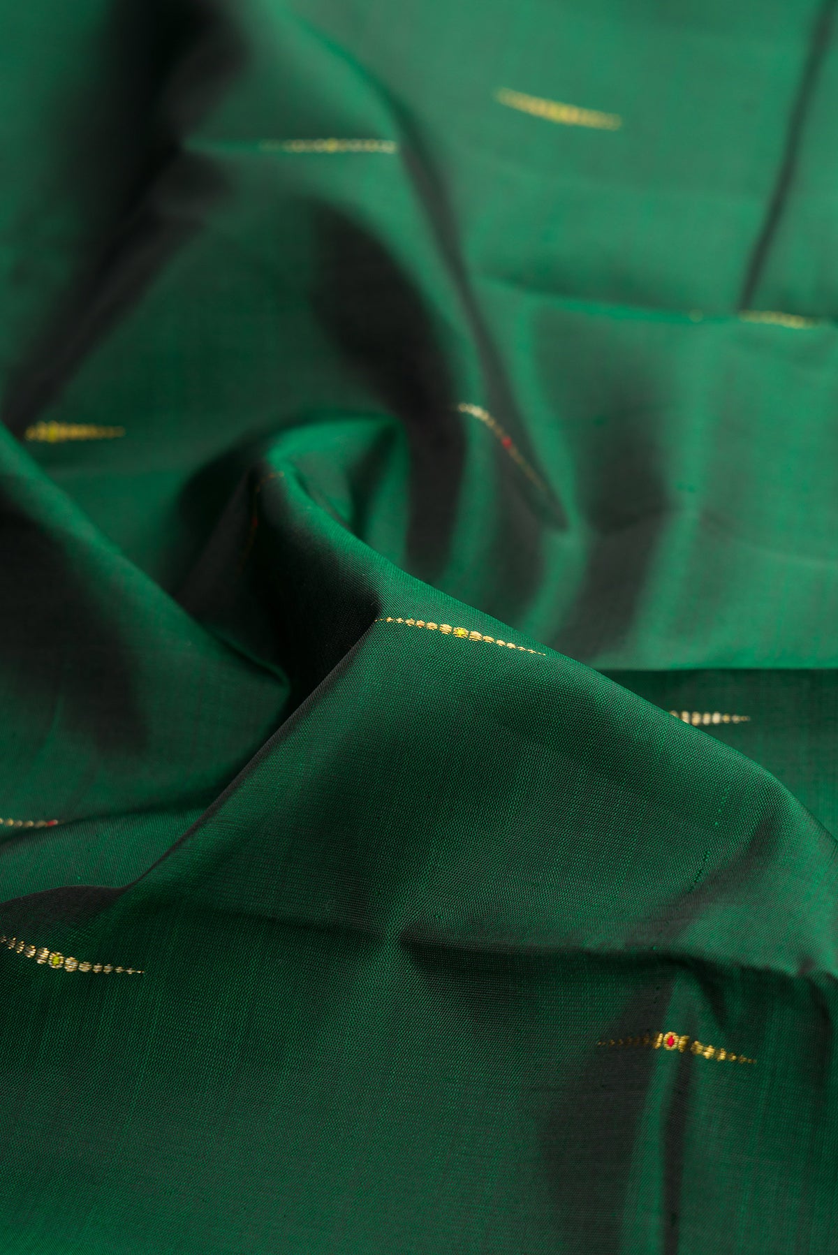 Close up of Pure Silk Pure Zari Bottle Green Kanjivaram Saree with Zari Butta on the body and Zari Border.  displaying folds