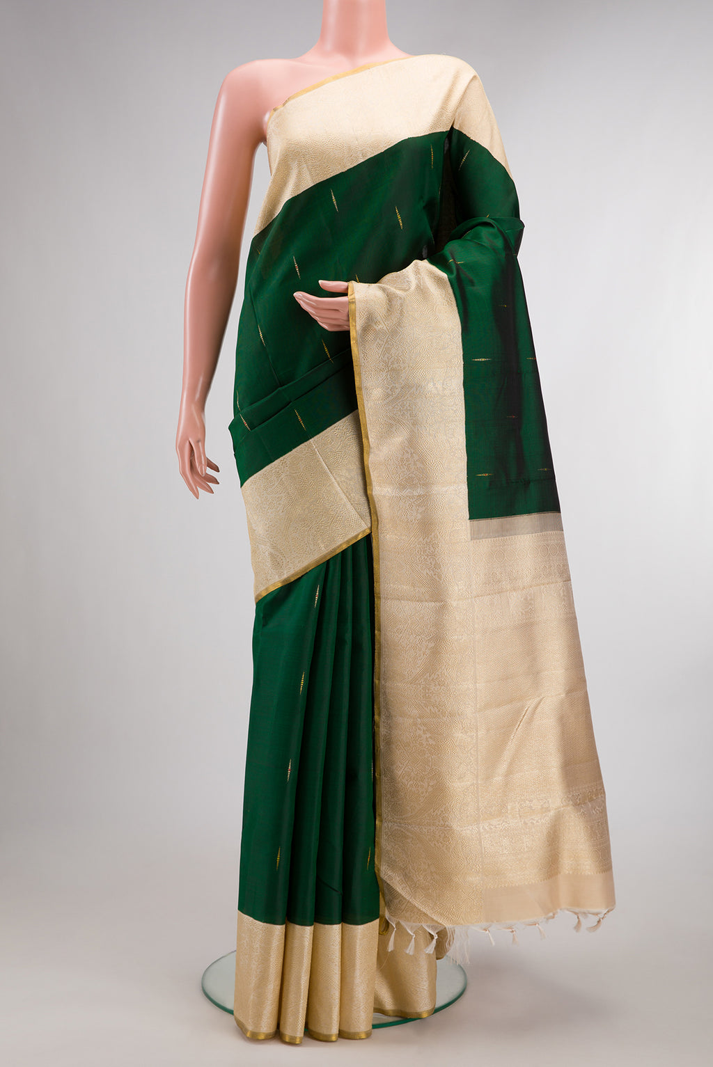 Pure Silk Pure Zari Bottle Green Kanjivaram Saree with Zari Butta on the body and Zari Border.  displayed on a mannequin