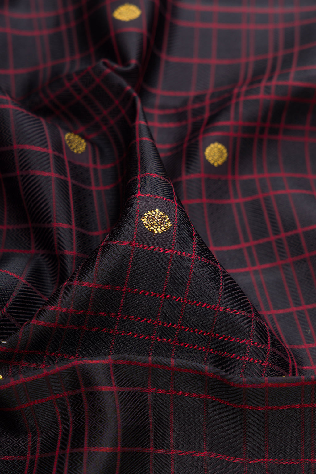 Close up of Pure Silk Pure Zari Black Kanchipuram Saree with Checked design on the body and Zari Border.  displaying folds