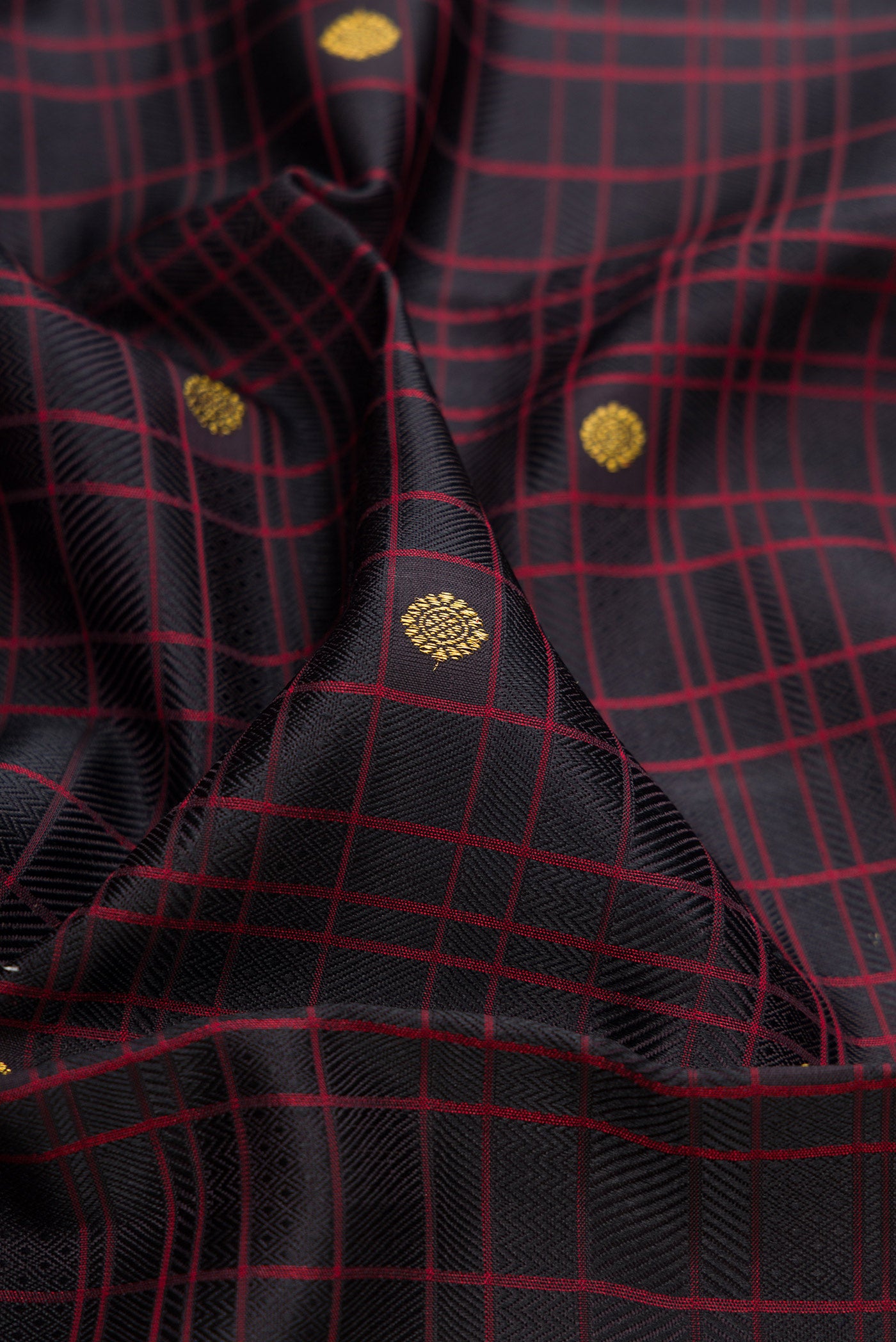 Close up of Pure Silk Pure Zari Black Kanchipuram Saree with Checked design on the body and Zari Border.  displaying folds