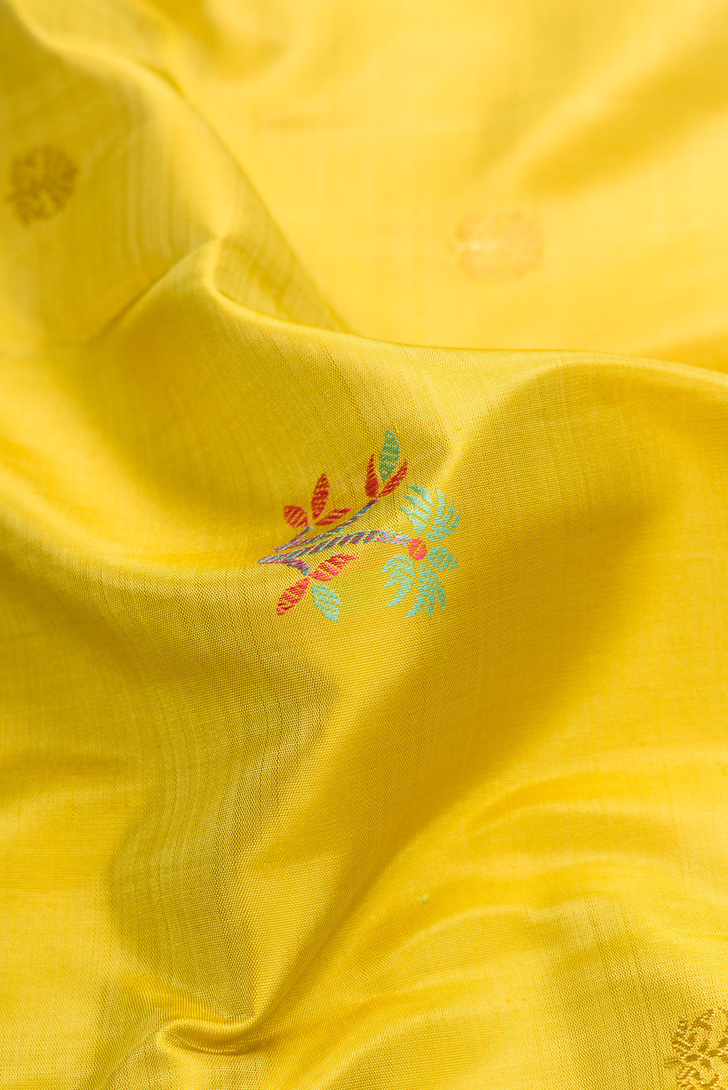 Close up of Pure Silk Pure Zari Lemon Yellow Dual Tone Kanchipuram Saree with Zari And Thread Butta on the body and Zari And Thread Border.  displaying folds