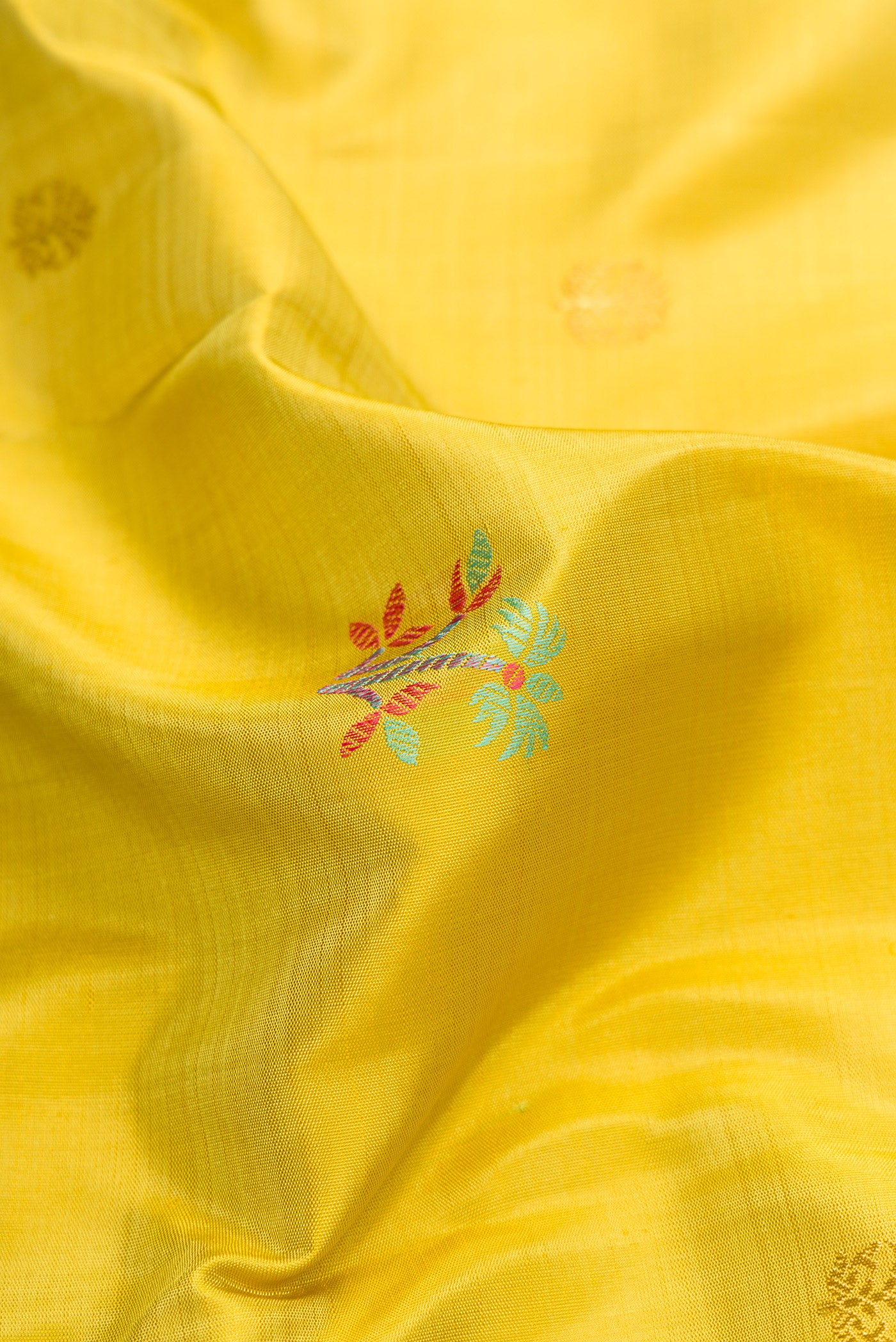 Close up of Pure Silk Pure Zari Lemon Yellow Dual Tone Kanchipuram Saree with Zari And Thread Butta on the body and Zari And Thread Border.  displaying folds