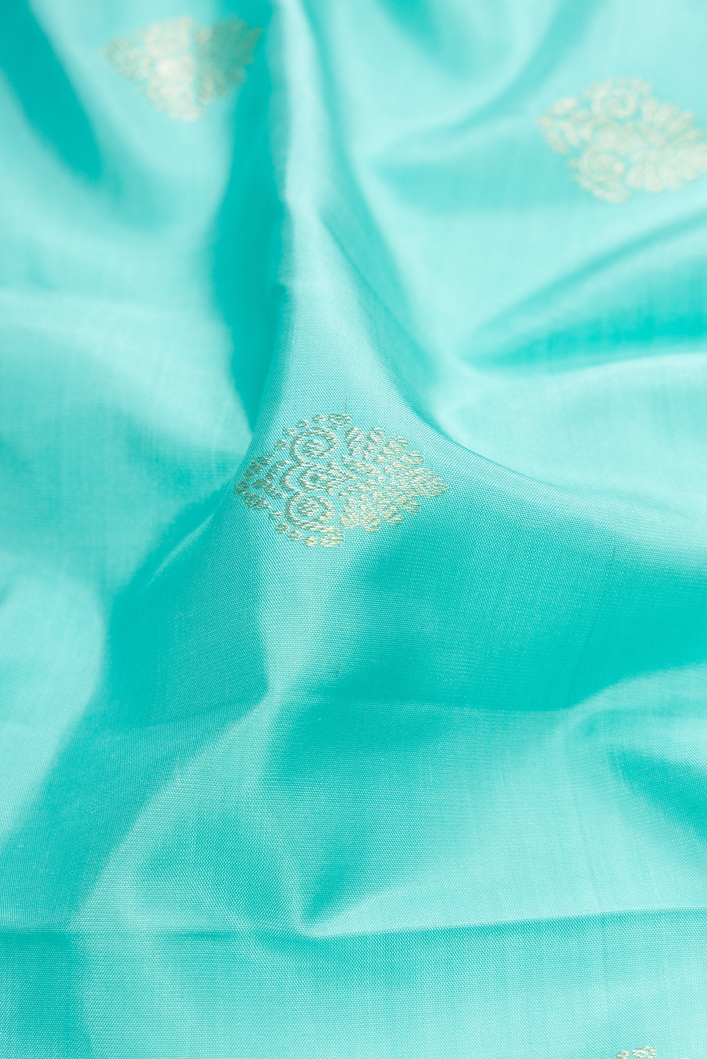 Close up of Sky Blue Dual Tone Kanjivaram Silk Saree with Zari Butta on the body and Fancy Border.  displaying folds