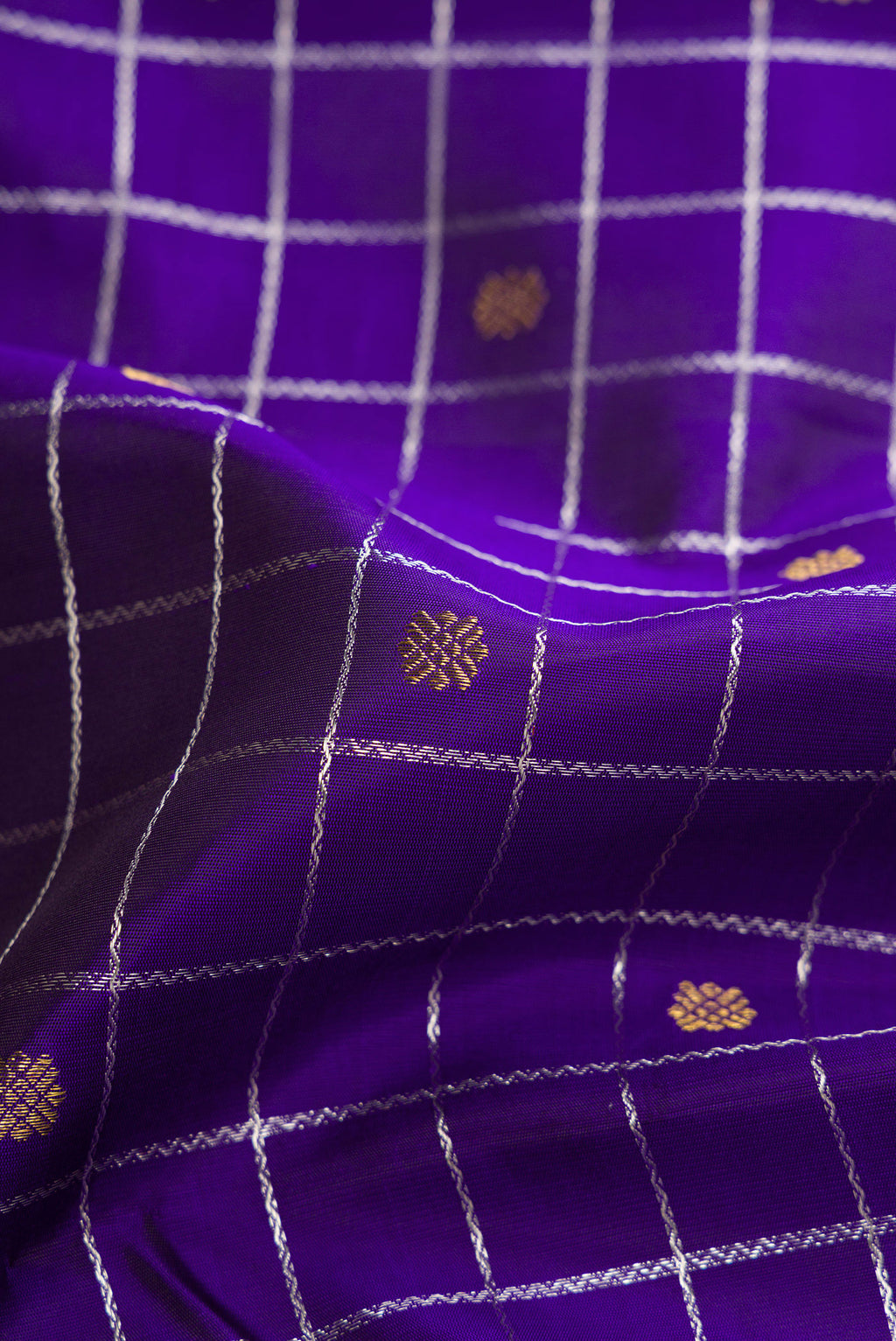 Close up of Pure Silk Pure Zari Violet Dual Tone Kanjivaram Saree with Checked design on the body and Without Border.  displaying folds