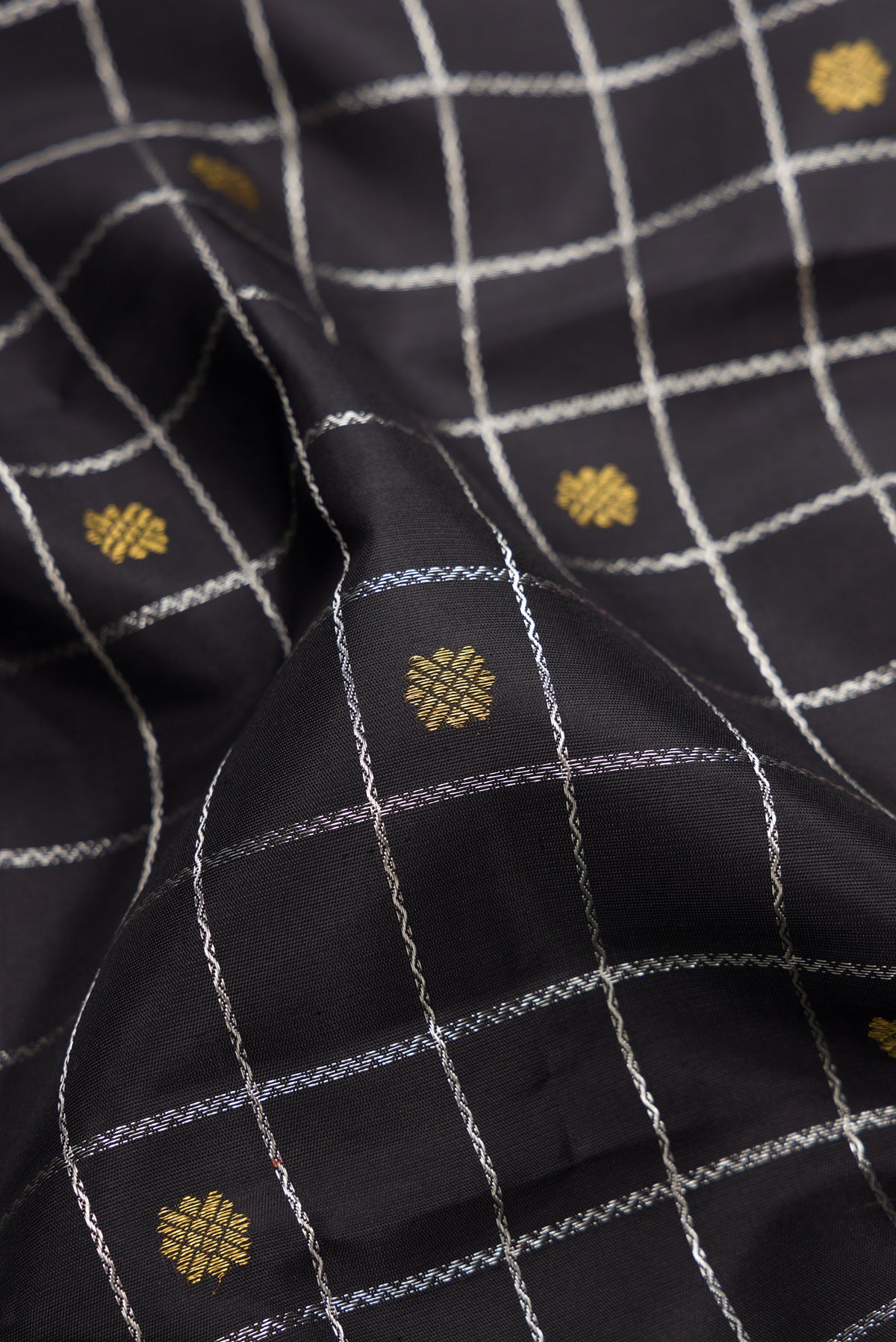 Close up of Pure Silk Pure Zari Black Dual Tone Kanjivaram Saree with Checked design on the body and Without Border.  displaying folds