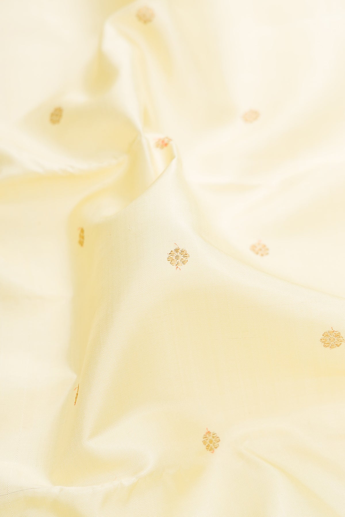 Close up of Pure Silk Pure Zari Off White Kanjivaram Saree with Zari Butta on the body and Zari Border.  displaying folds