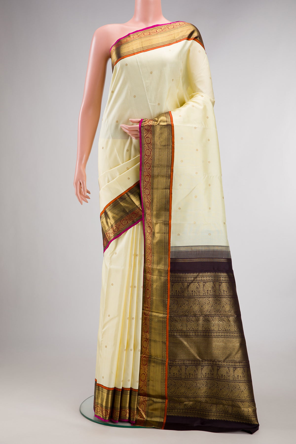 Pure Silk Pure Zari Off White Kanjivaram Saree with Zari Butta on the body and Zari Border.  displayed on a mannequin