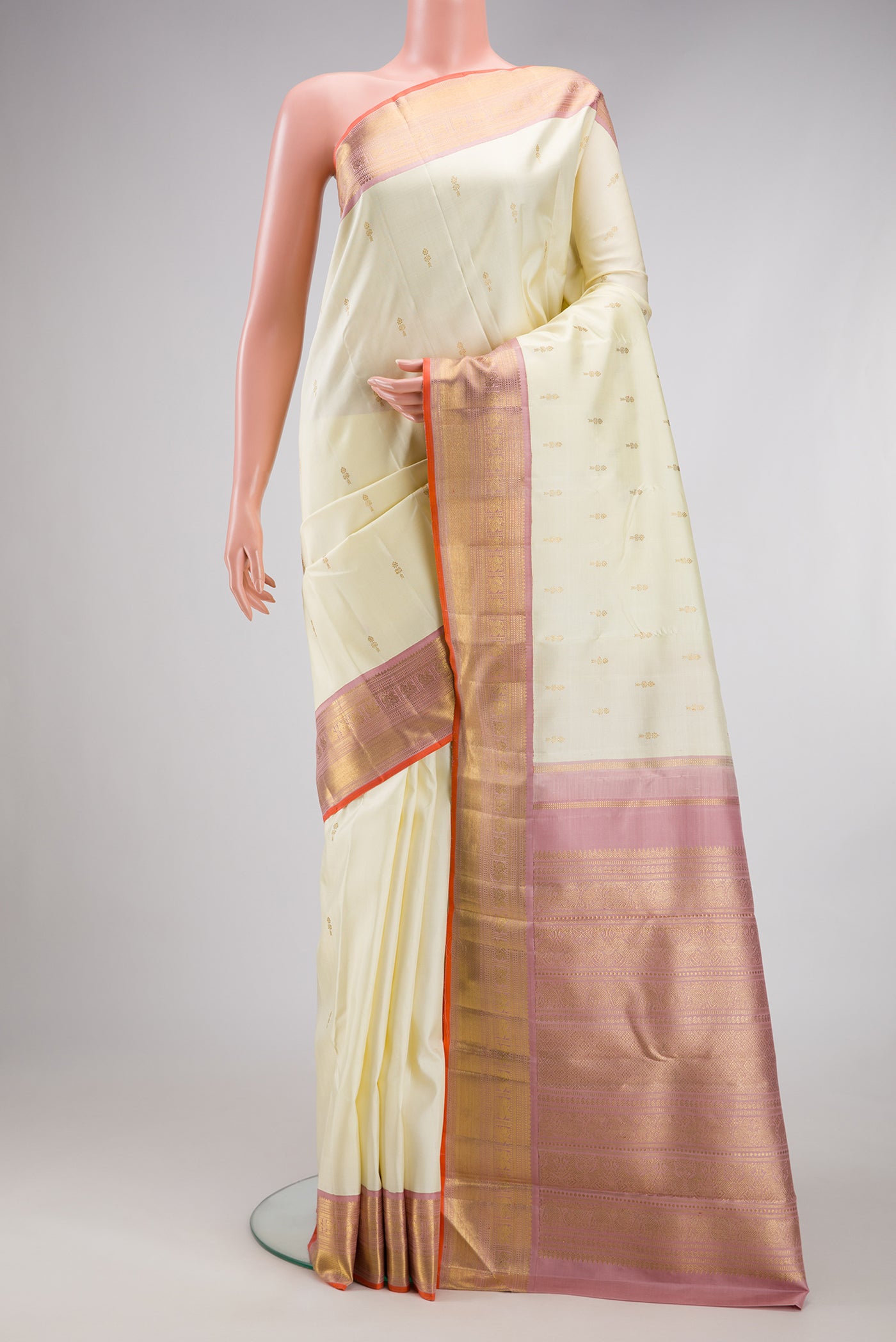 Pure Silk Pure Zari Off White Kanjivaram Saree with Zari Butta on the body and Zari Border.  displayed on a mannequin