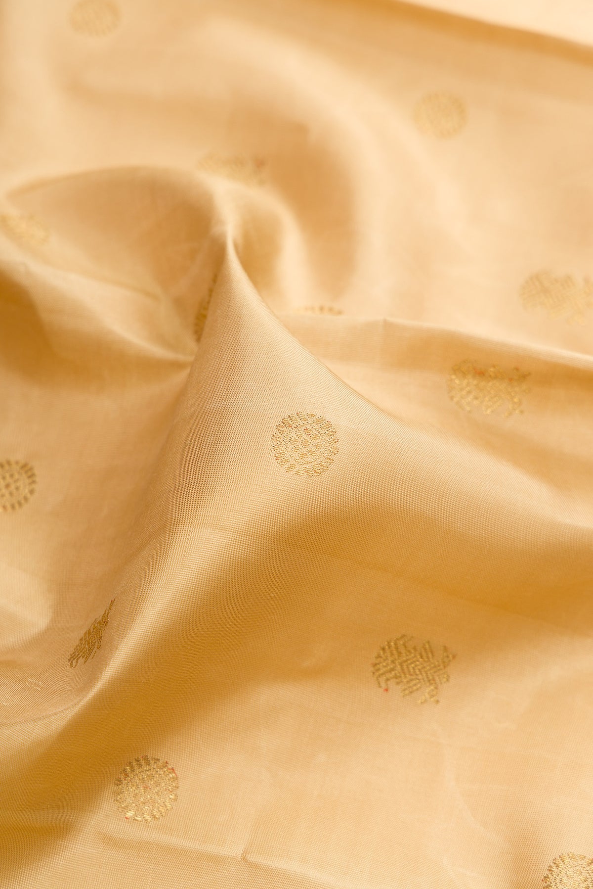 Close up of Pure Silk Pure Zari Beige Kanjivaram Saree with Zari Butta on the body and Zari Border.  displaying folds