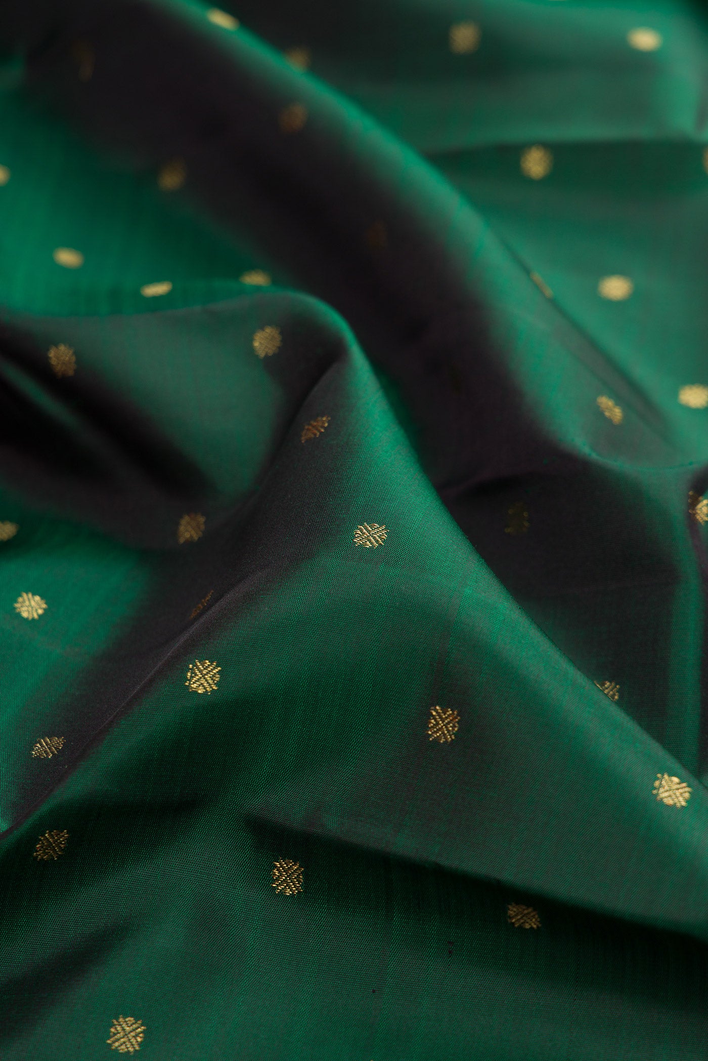 Close up of Pure Silk Pure Zari Bottle Green Kanjivaram Saree with Zari Butta on the body and Zari Border.  displaying folds