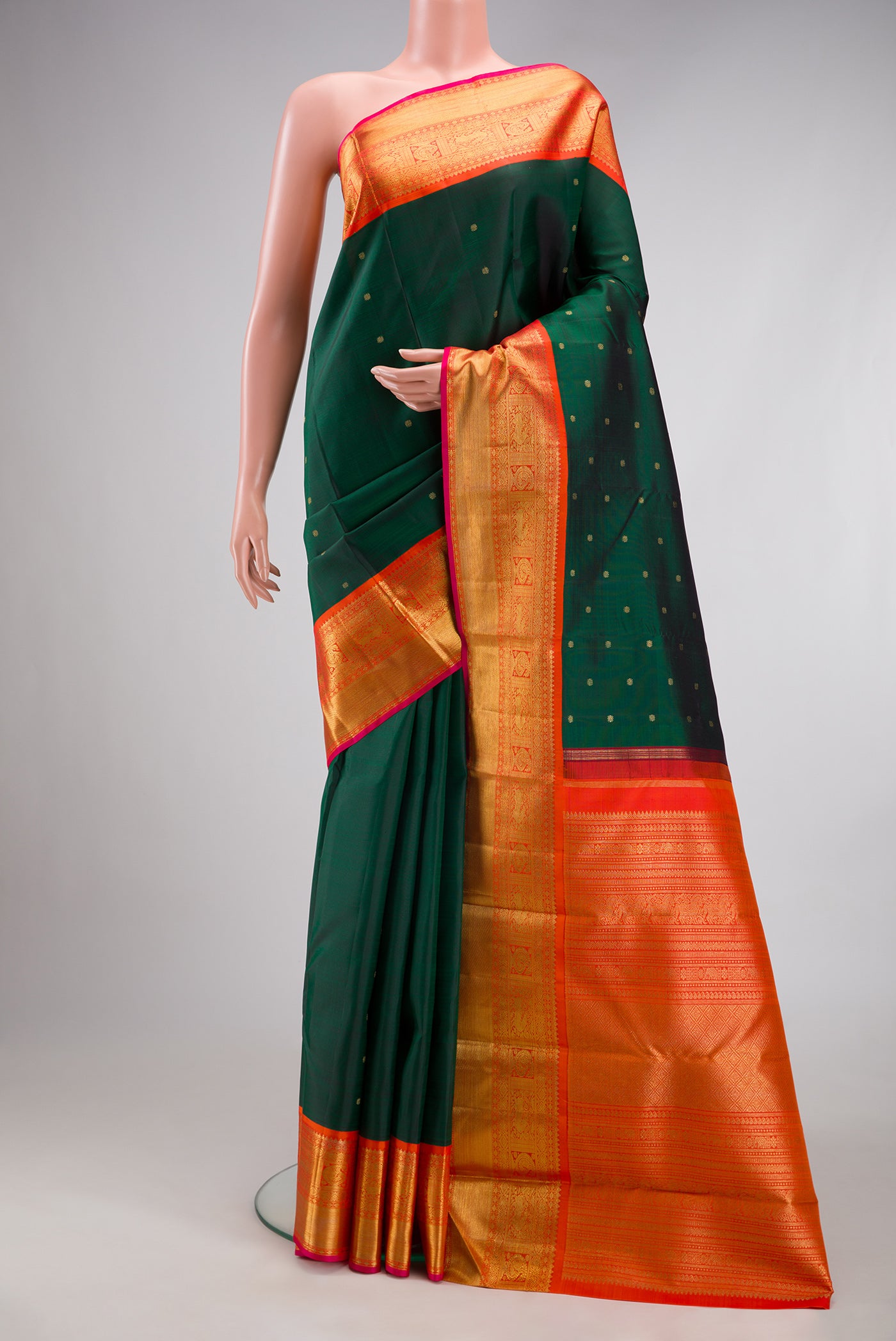 Pure Silk Pure Zari Bottle Green Kanjivaram Saree with Zari Butta on the body and Zari Border.  displayed on a mannequin
