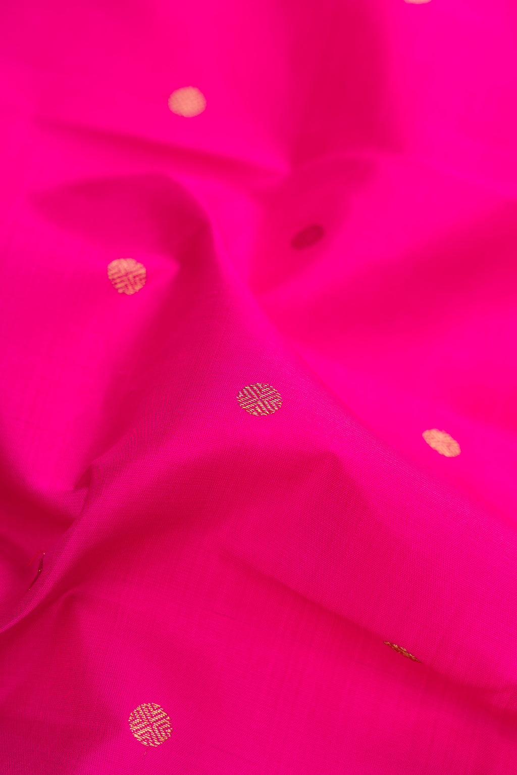 Close up of Pure Silk Pure Zari Dark Pink Kanjivaram Saree with Zari Butta on the body and Fancy Border.  displaying folds