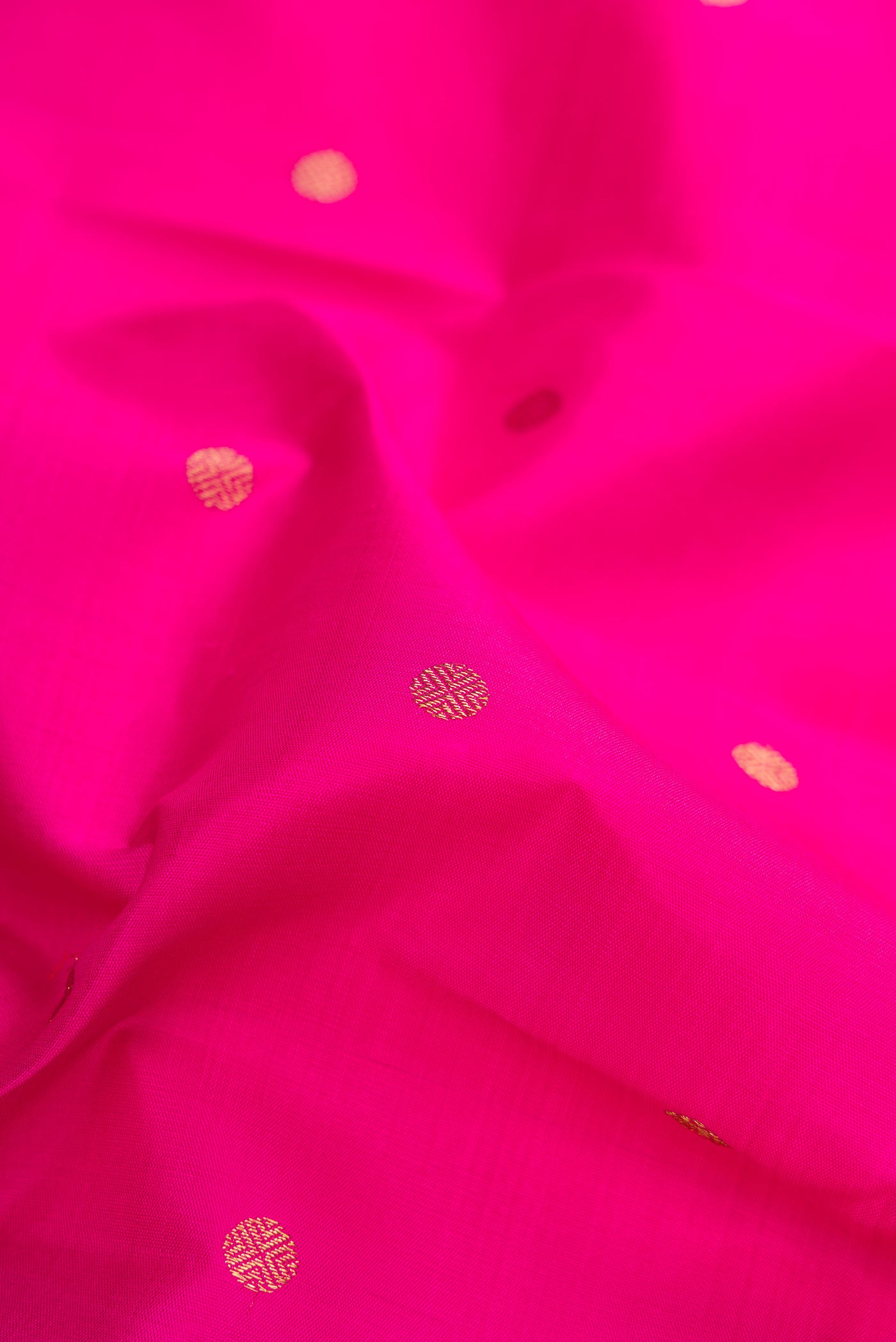 Close up of Pure Silk Pure Zari Dark Pink Kanjivaram Saree with Zari Butta on the body and Fancy Border.  displaying folds