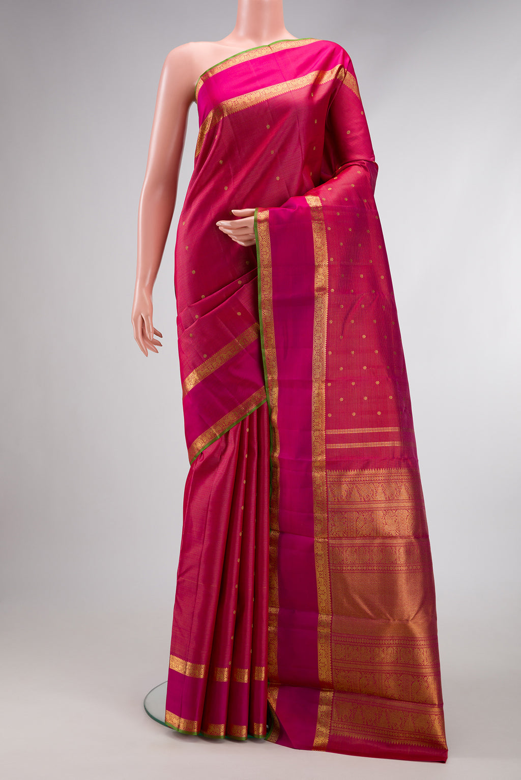 Pure Silk Pure Zari Rani Pink Kanjivaram Saree with Zari Butta on the body and Zari Border.  displayed on a mannequin