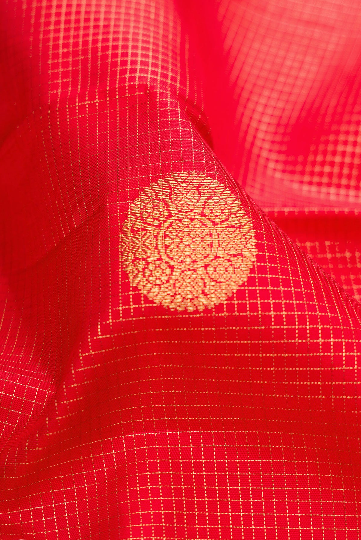 Close up of Pure Silk Pure Zari Red Dual Tone Kanjivaram Saree with Checked design on the body and Zari Border.  displaying folds