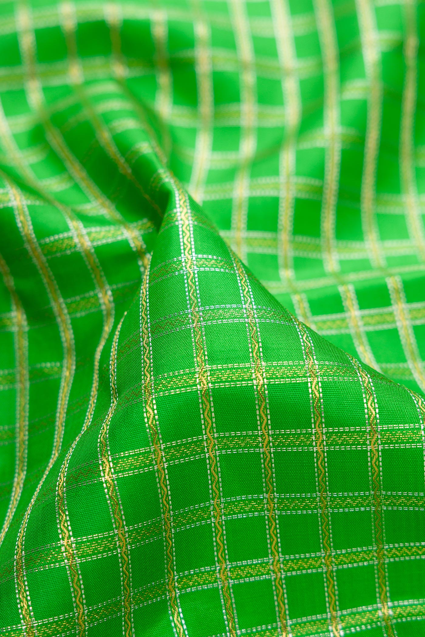 Close up of Pure Silk Pure Zari Parrot Green Dual Tone Kanjivaram Saree with Checked design on the body and Zari Border.  displaying folds