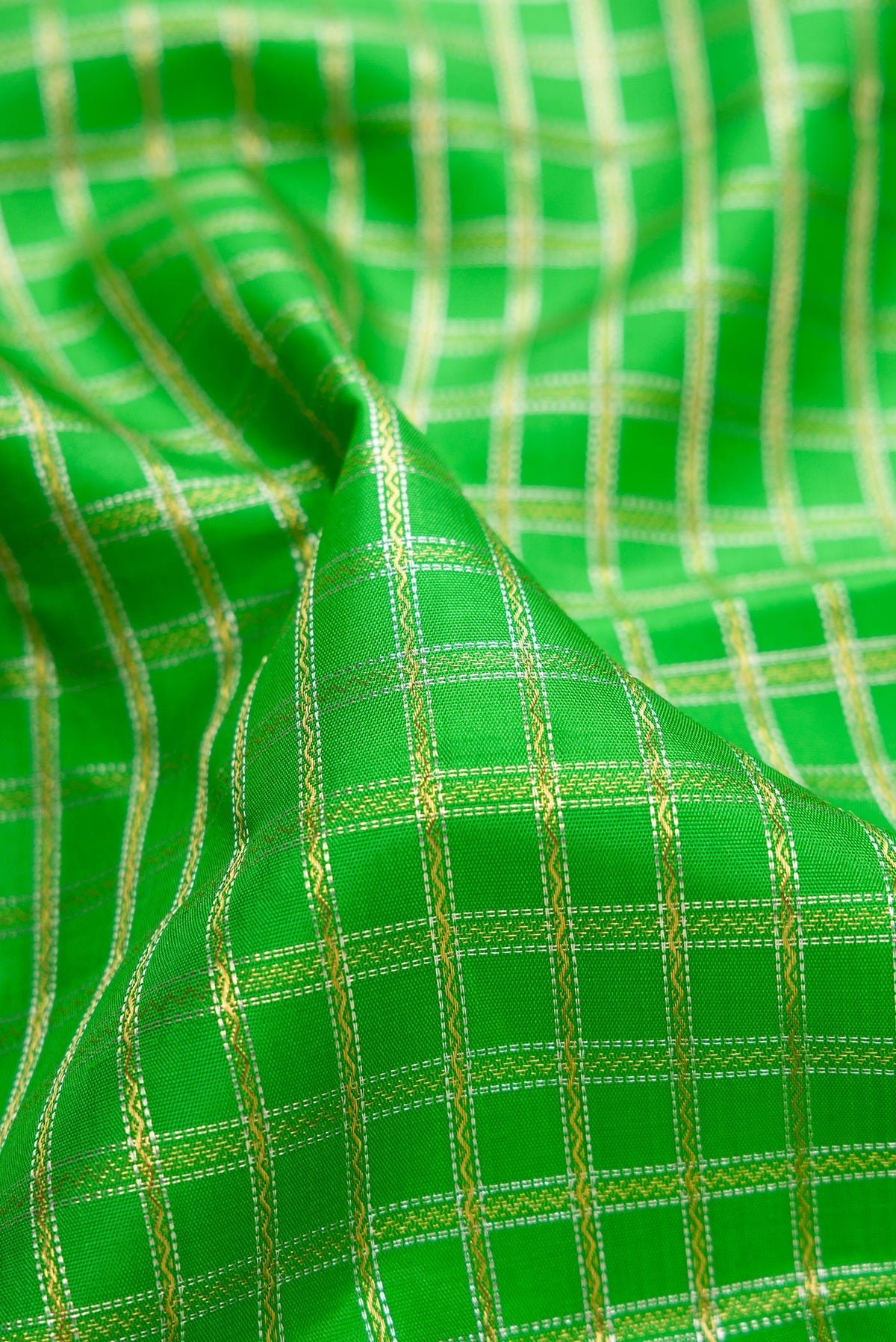 Close up of Pure Silk Pure Zari Parrot Green Dual Tone Kanjivaram Saree with Checked design on the body and Zari Border.  displaying folds