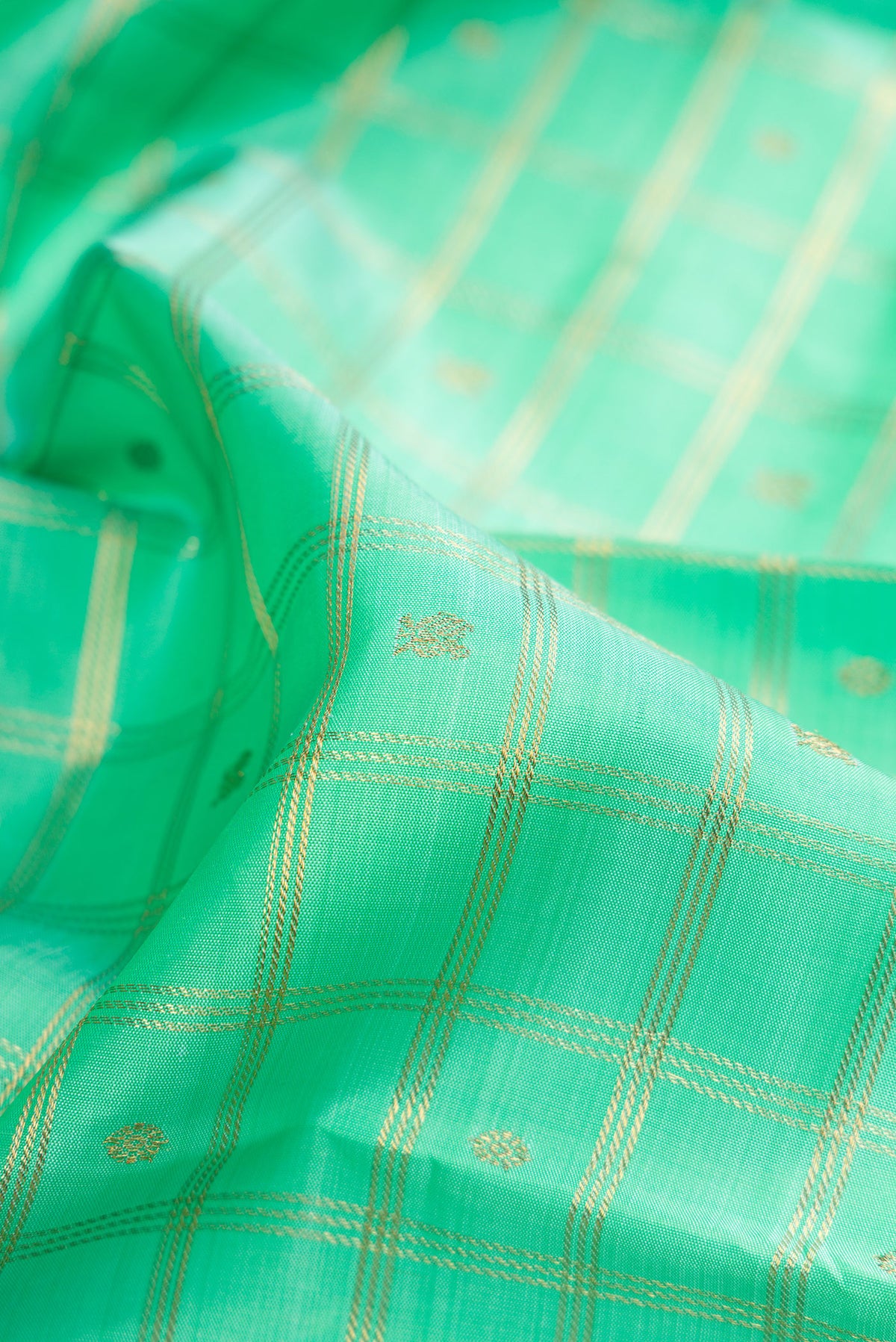 Close up of Pure Silk Pure Zari Sea Green Dual Tone Kanjivaram Saree with Checked design on the body and Zari Border.  displaying folds