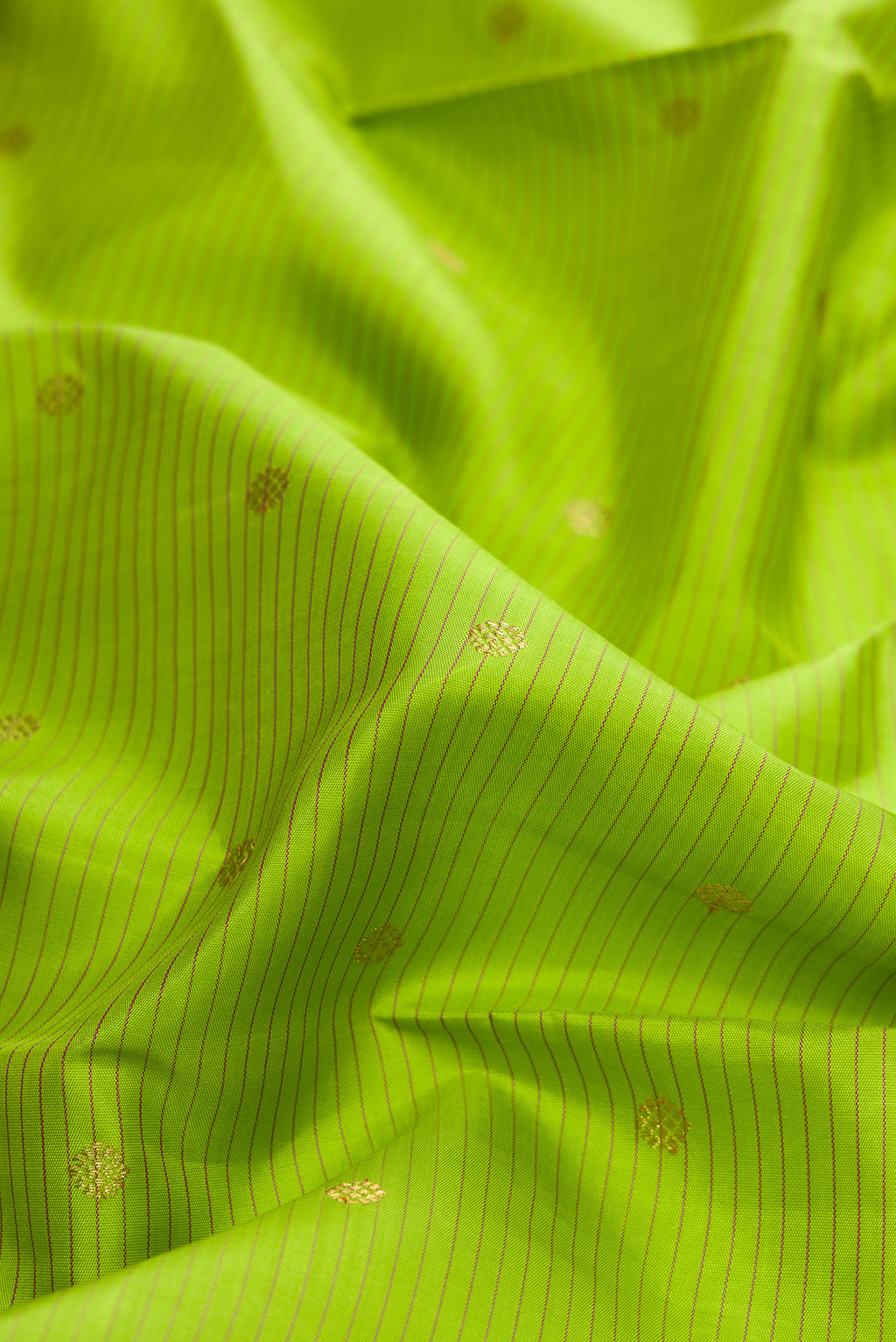 Close up of Pure Silk Pure Zari Parrot Green Dual Tone Kanchipuram Saree with Stripes on the body and Zari Border.  displaying folds