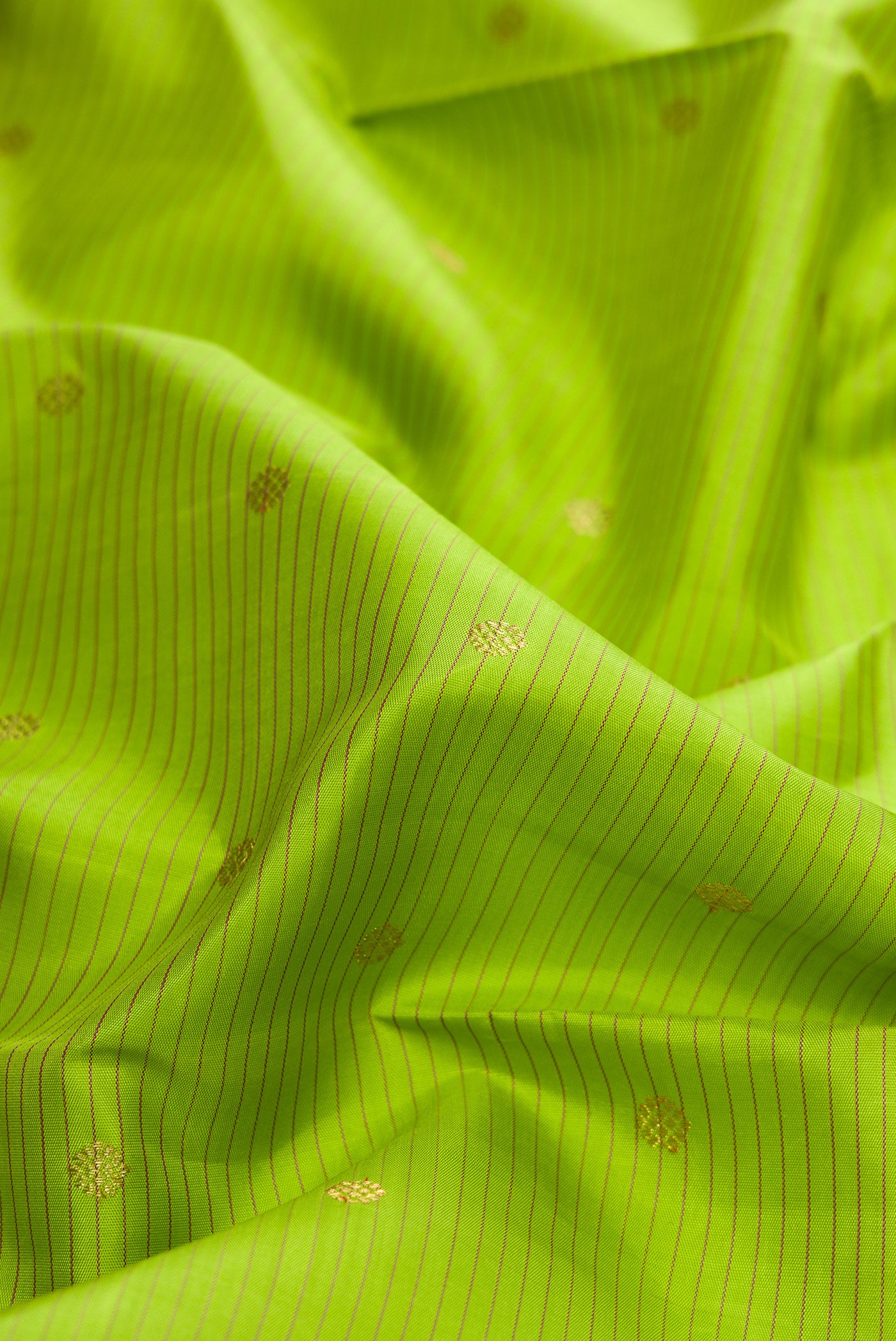 Close up of Pure Silk Pure Zari Parrot Green Dual Tone Kanchipuram Saree with Stripes on the body and Zari Border.  displaying folds