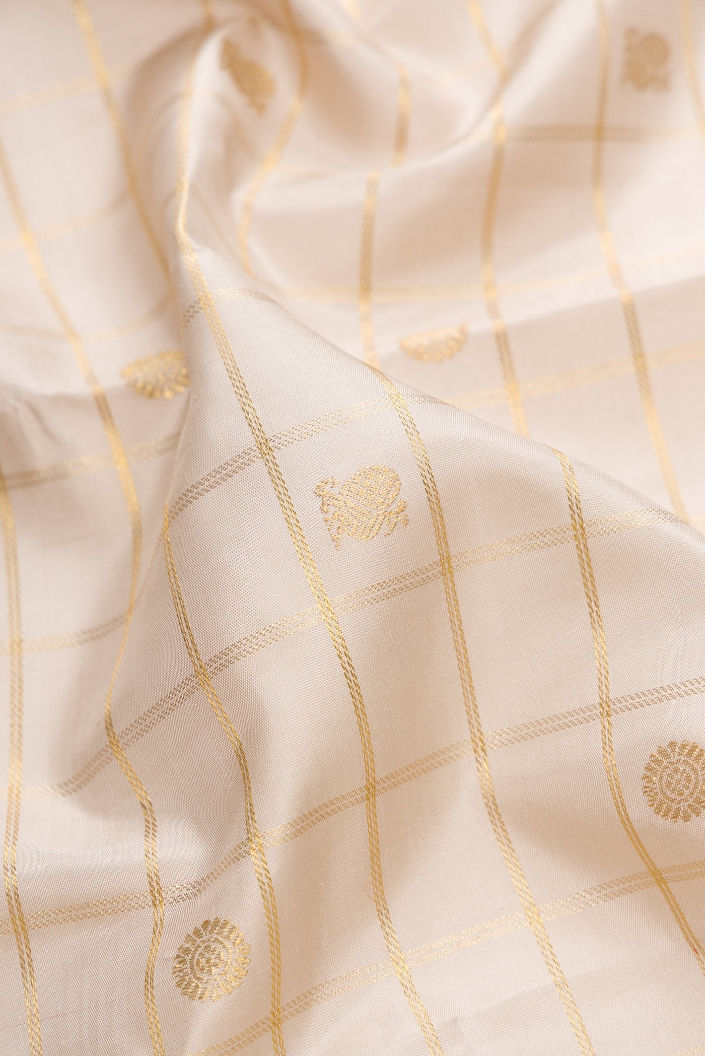 Close up of Pure Silk Pure Zari Off White Dual Tone Kanjivaram Saree with Checked design on the body and Zari Border.  displaying folds