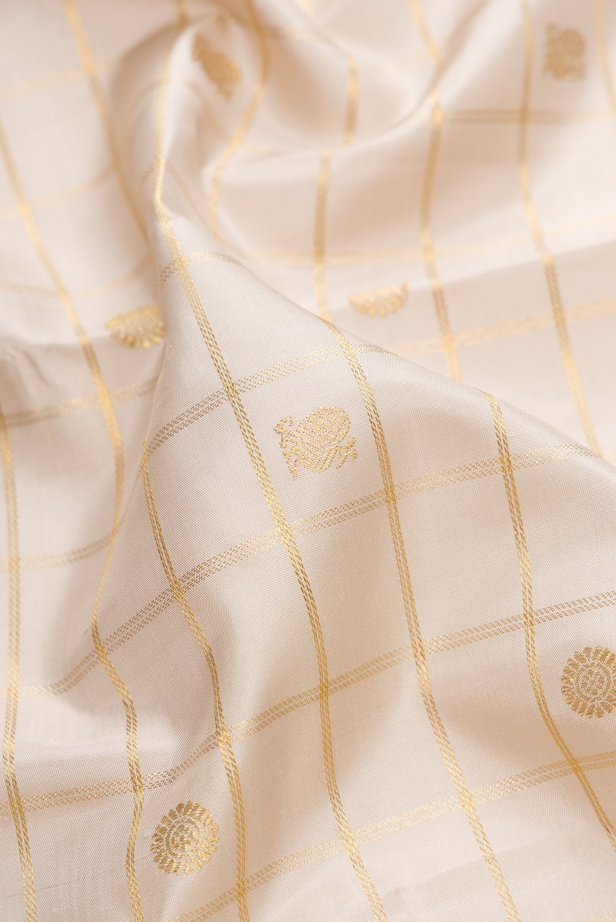 Close up of Pure Silk Pure Zari Off White Dual Tone Kanjivaram Saree with Checked design on the body and Zari Border.  displaying folds