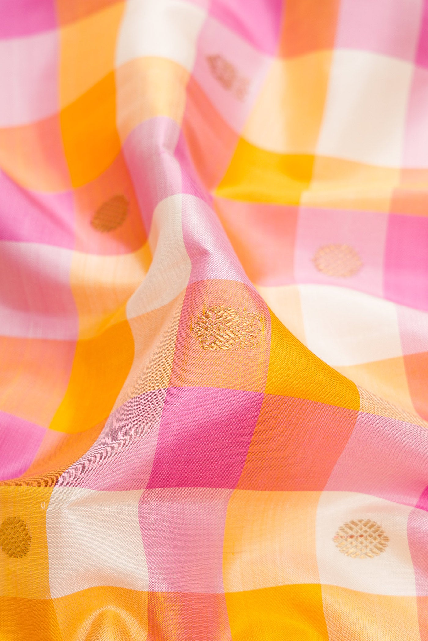 Close up of Pure Silk Pure Zari Mustard, Pink and Off White Color Kanjivaram Saree with Checked design on the body and Zari Border.  displaying folds